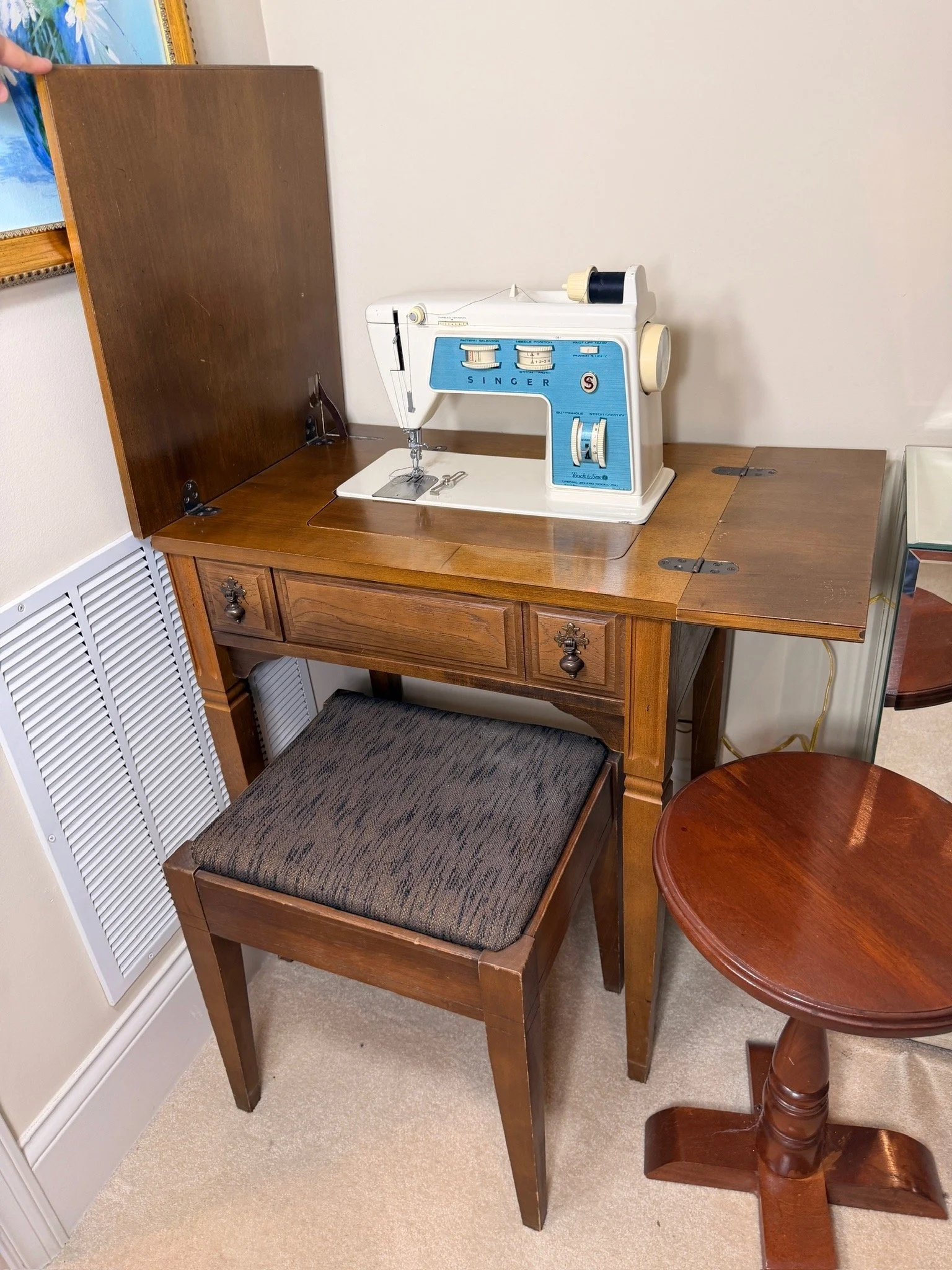 Singer sewing machine open in drop-leaf sewing desk