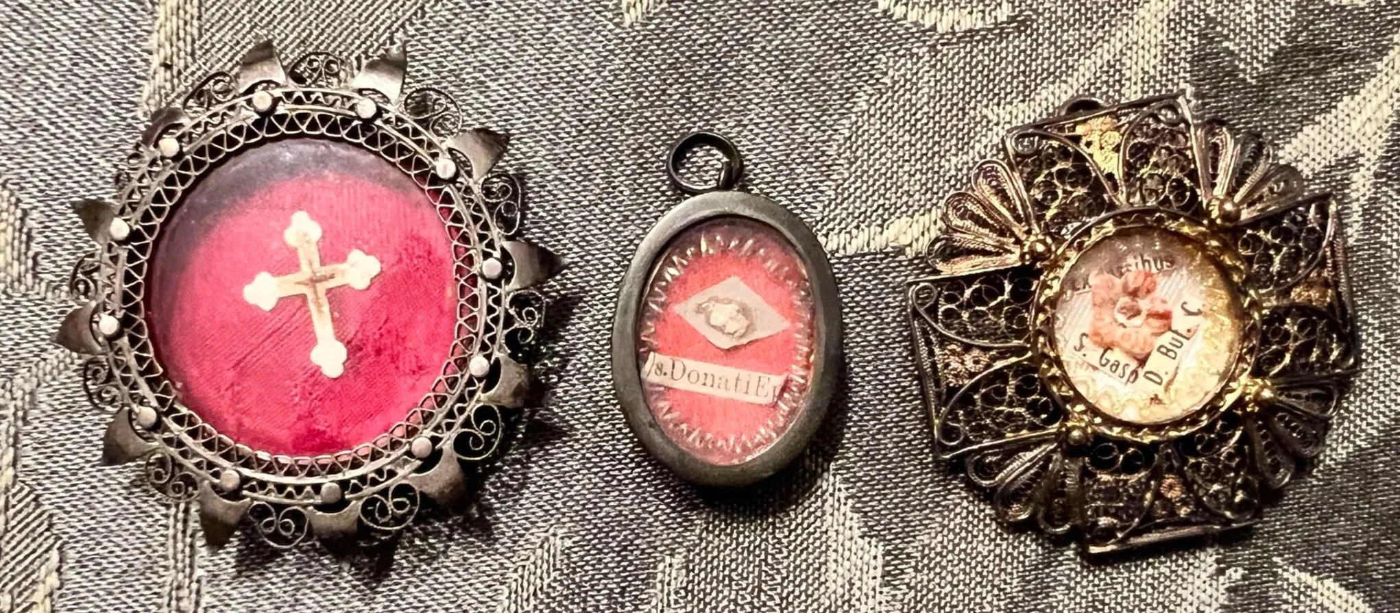 Three ornate filigree reliquaries containing sacred remnants of Saint Gaspar del Bufalo, Saint Donatus, and a fragment of the True Cross