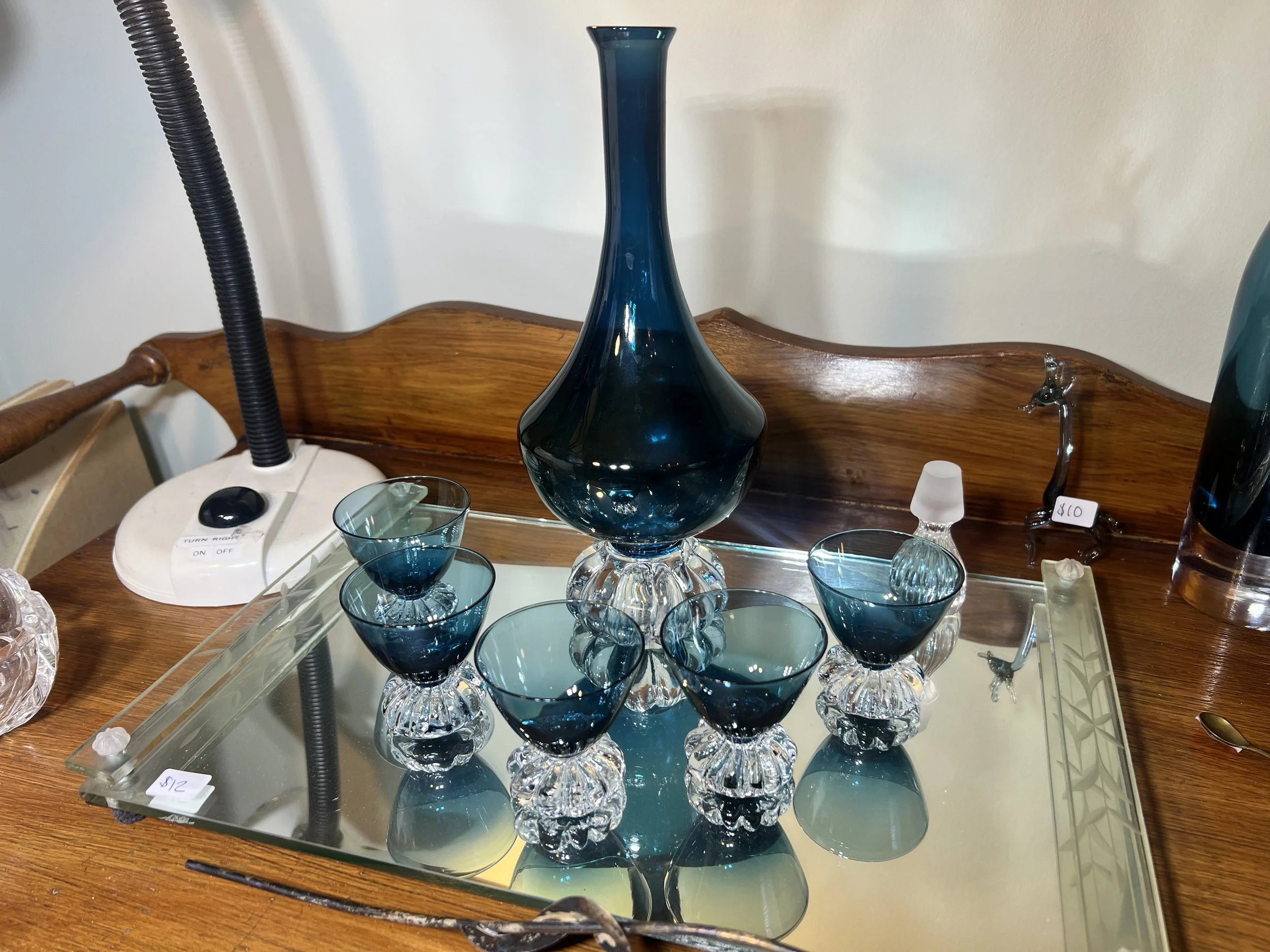 Stunning teal-blue glassware set including a tall tapered vase, a bulbous decanter, and matching stemmed cordial glassester and glasses