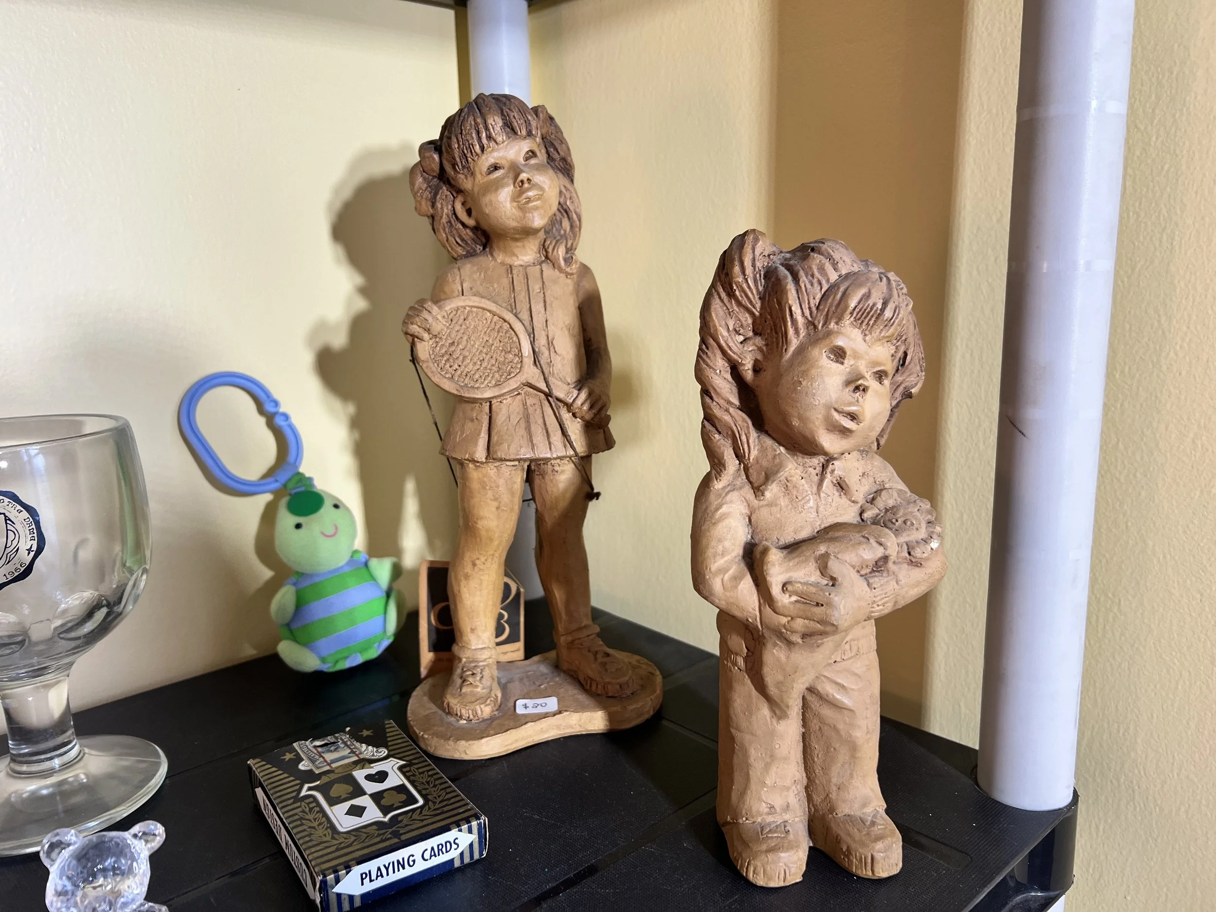 Sandicast-style figurines of a young tennis player and a girl with a puppy, shown alongside vintage playing cards