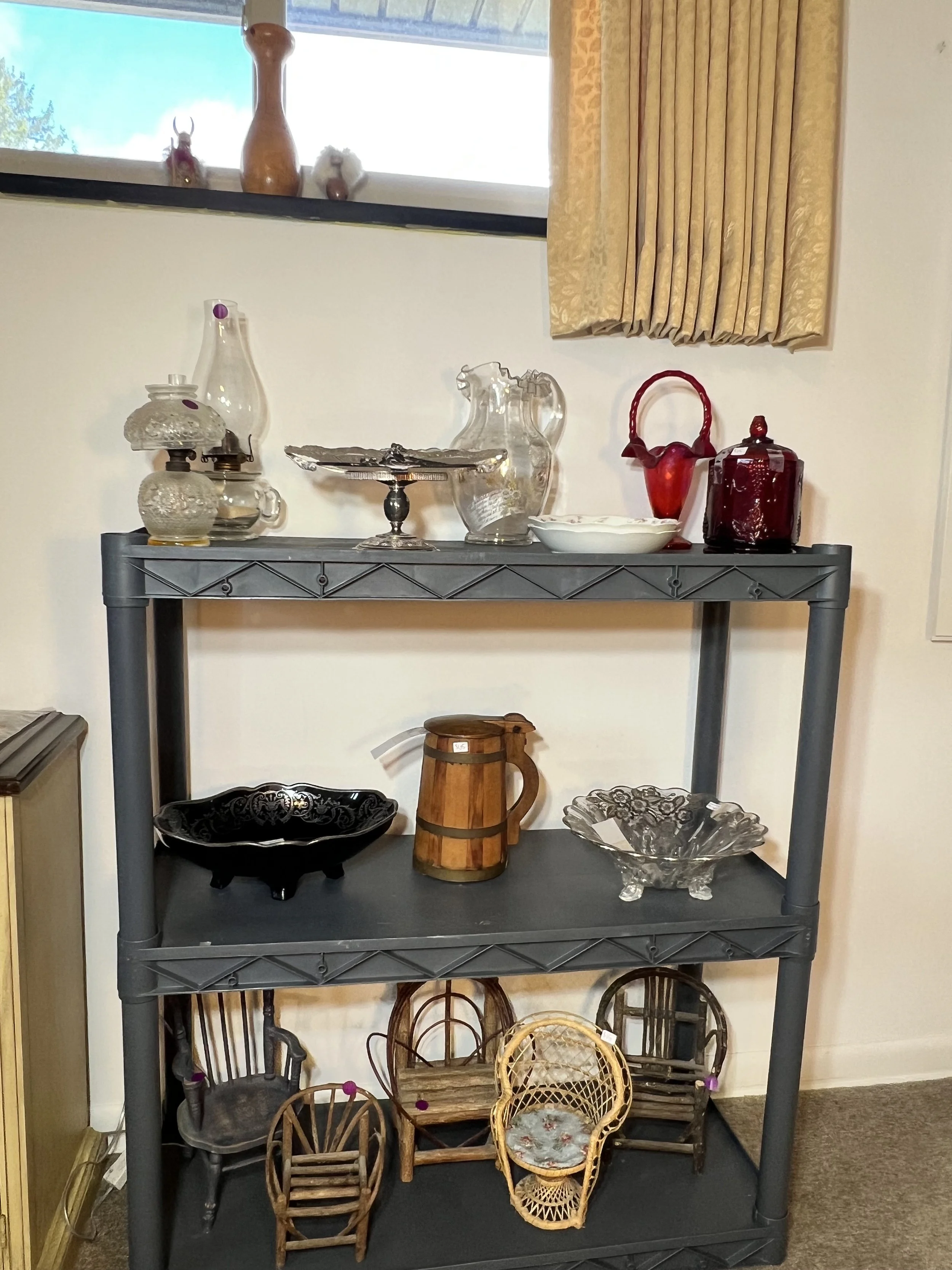 Display shelf featuring ruby red cranberry glass, etched crystal, and miniature rustic chairs