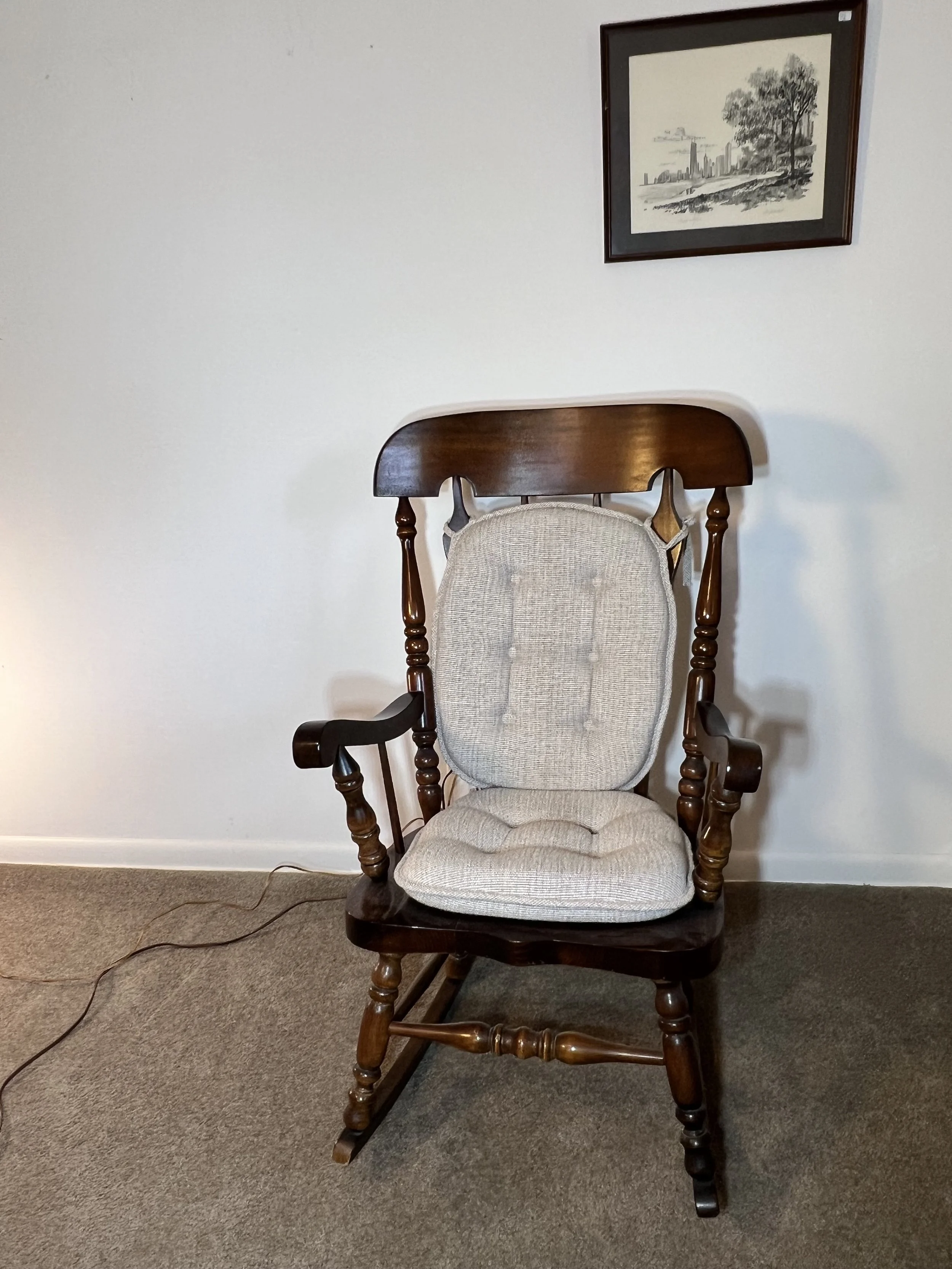 Stately dark wood rocking chair featuring a neutral-toned padded seat and back