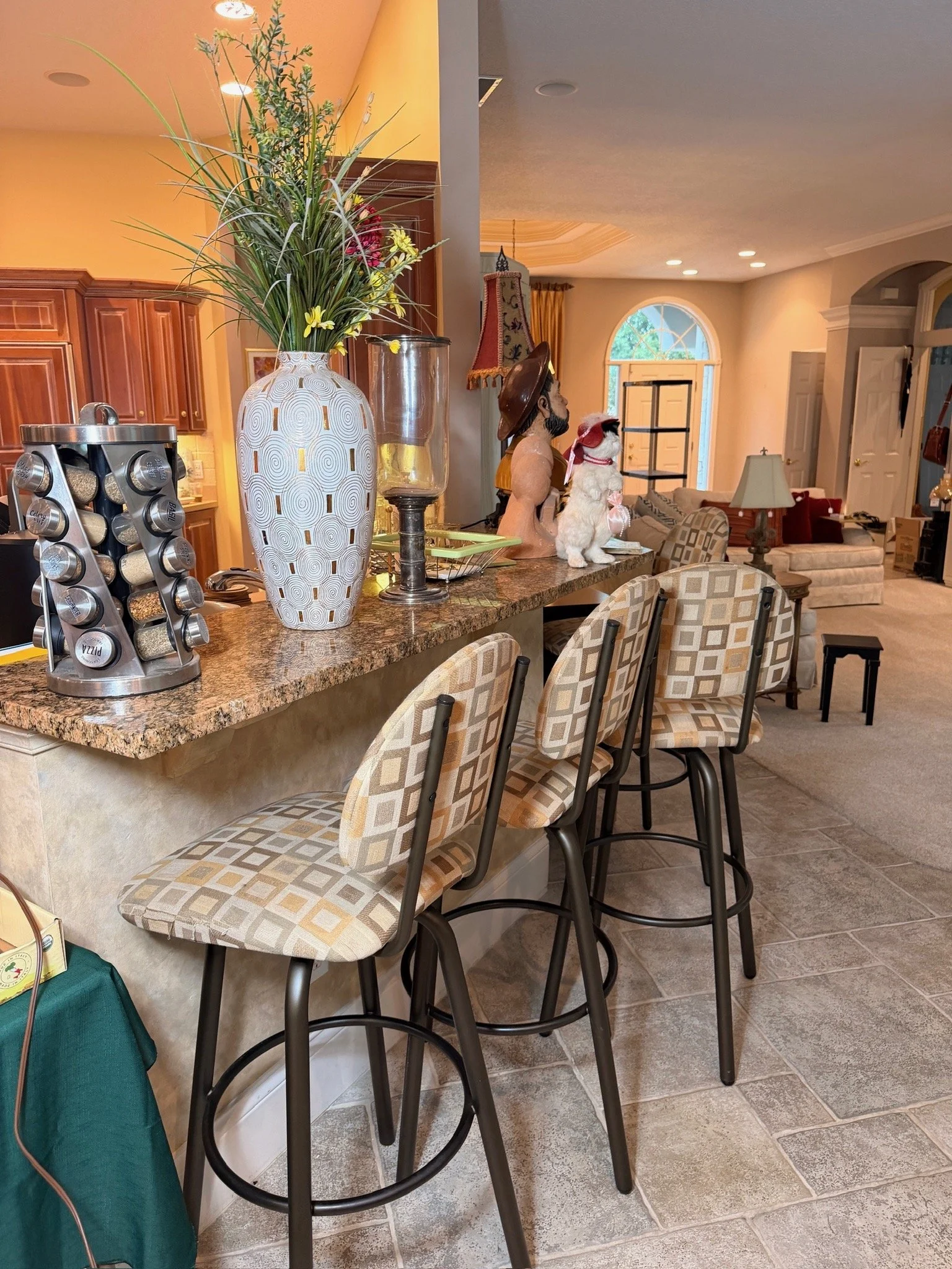 Four patterned upholstered swivel barstools and a rotating spice rack