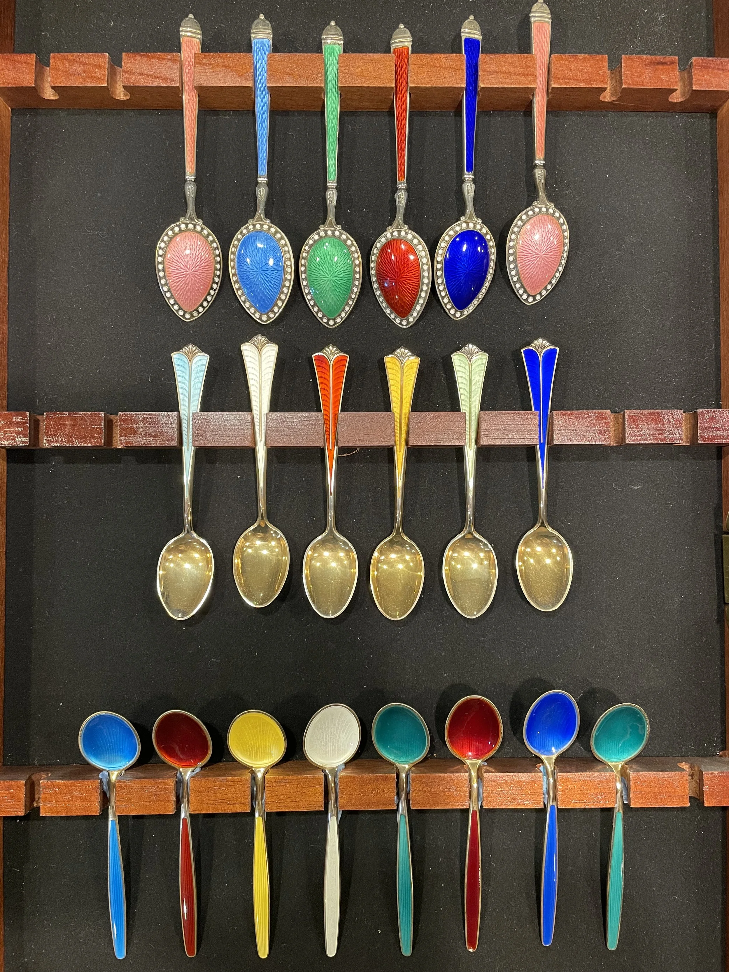 A magnificent showcase of Norwegian David-Andersen sterling silver demitasse spoons featuring vibrant jewel-toned guilloché enamel