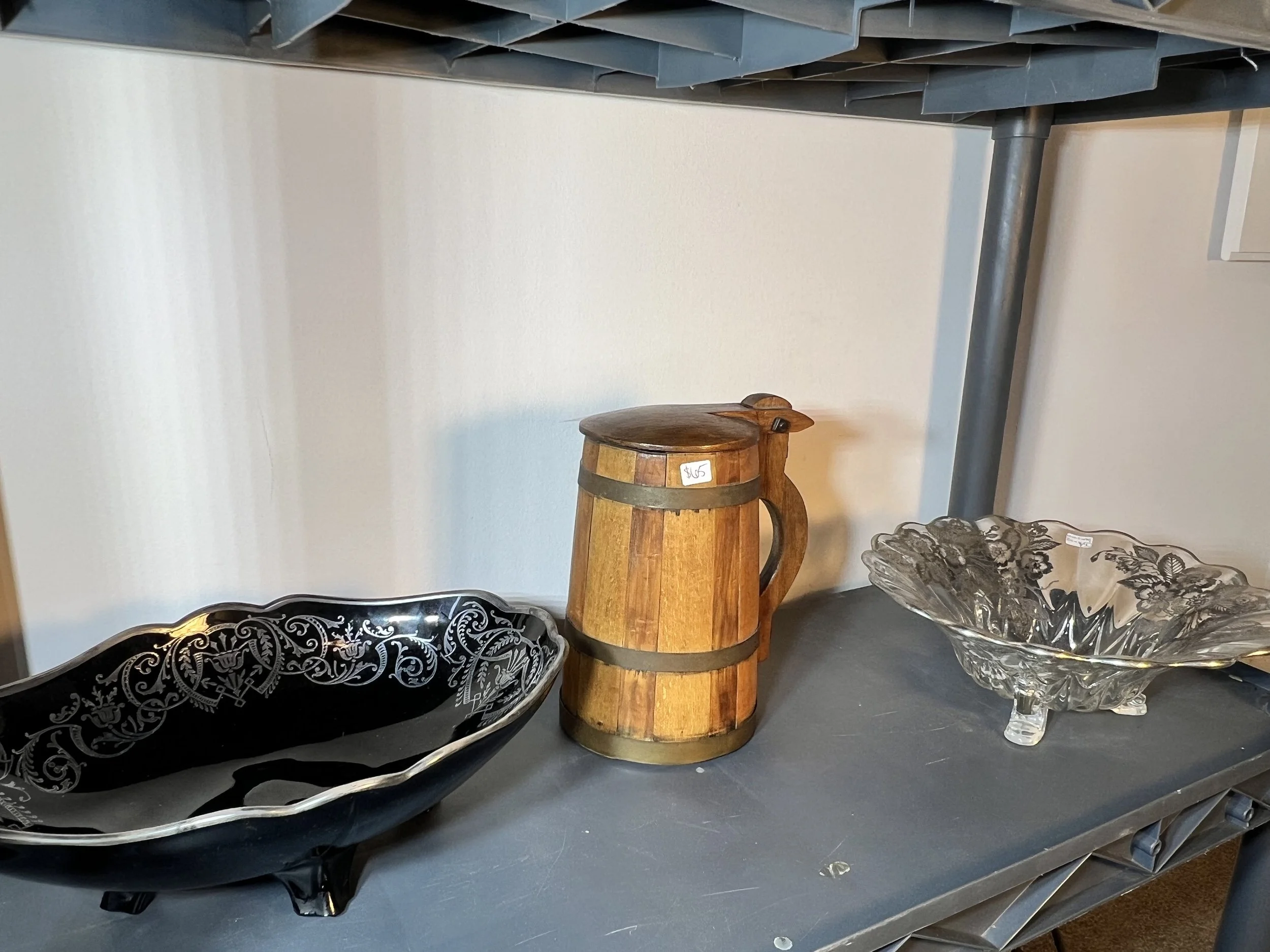 Ornate silver-trimmed black glassware shown alongside a vintage wooden tankard