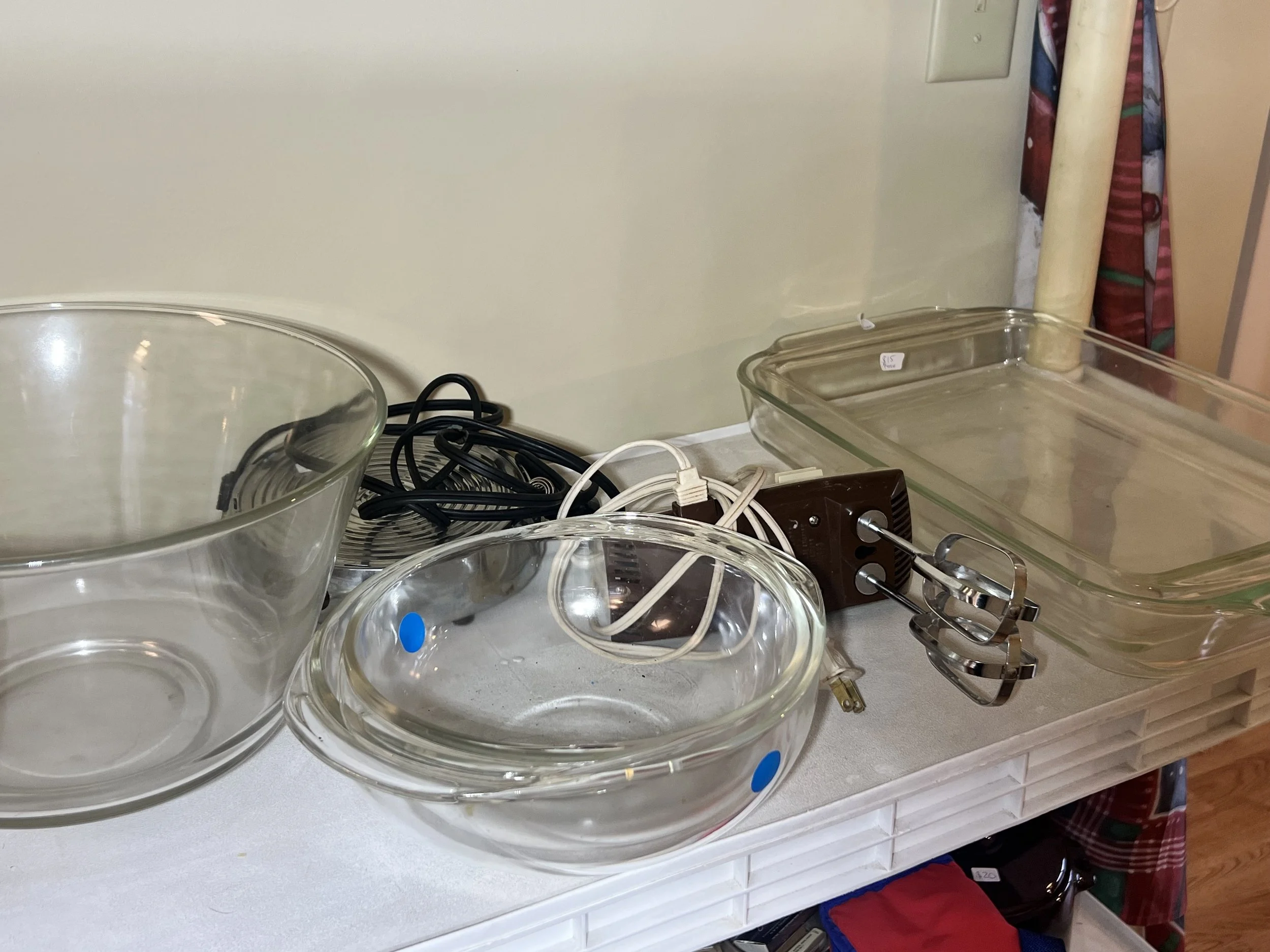 A clear Pyrex glass mixing bowl, a baking pan, and a vintage Sunbeam hand mixer
