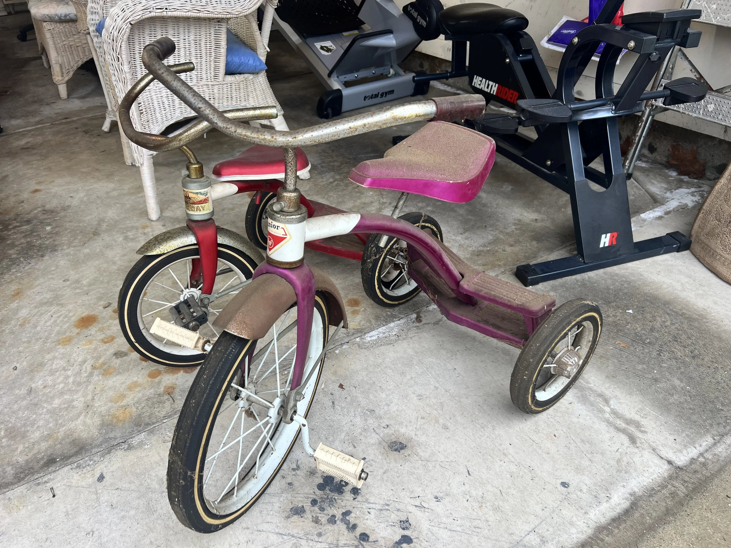 "Junior" brand metal tricycles with classic swept-back handlebars and original patina