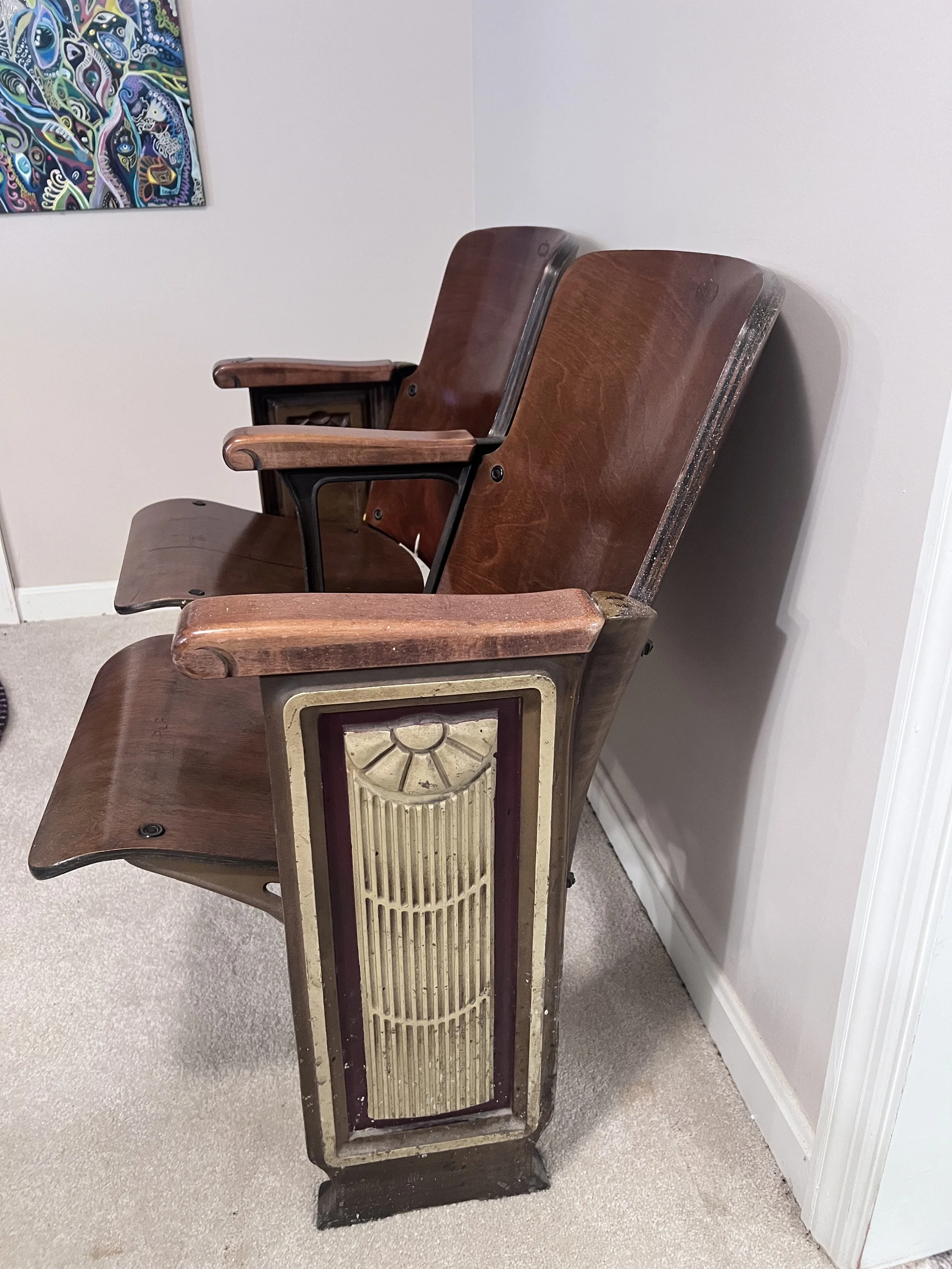 Wooden double-seat theater bench featuring ornate Art Deco metal end panels