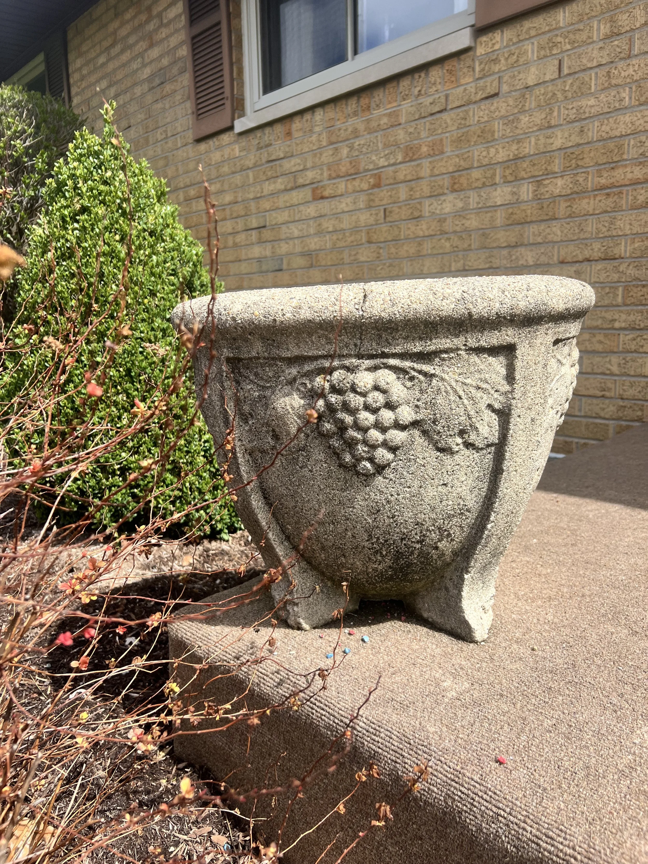 Heavy concrete garden planter featuring a raised grape and leaf design