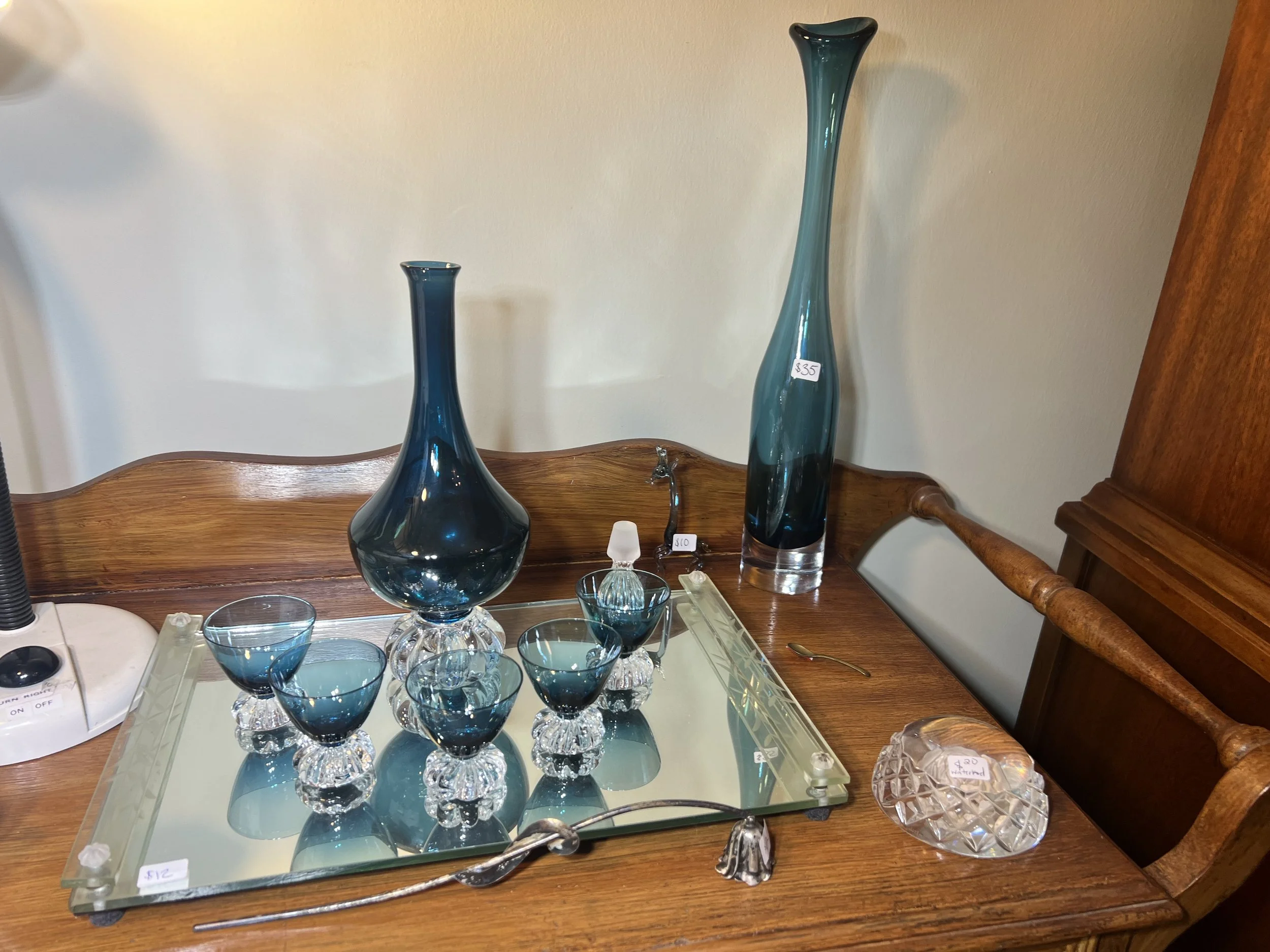 Stunning teal-blue glassware set including a tall tapered vase, a bulbous decanter, and matching stemmed cordial glassester and glasses