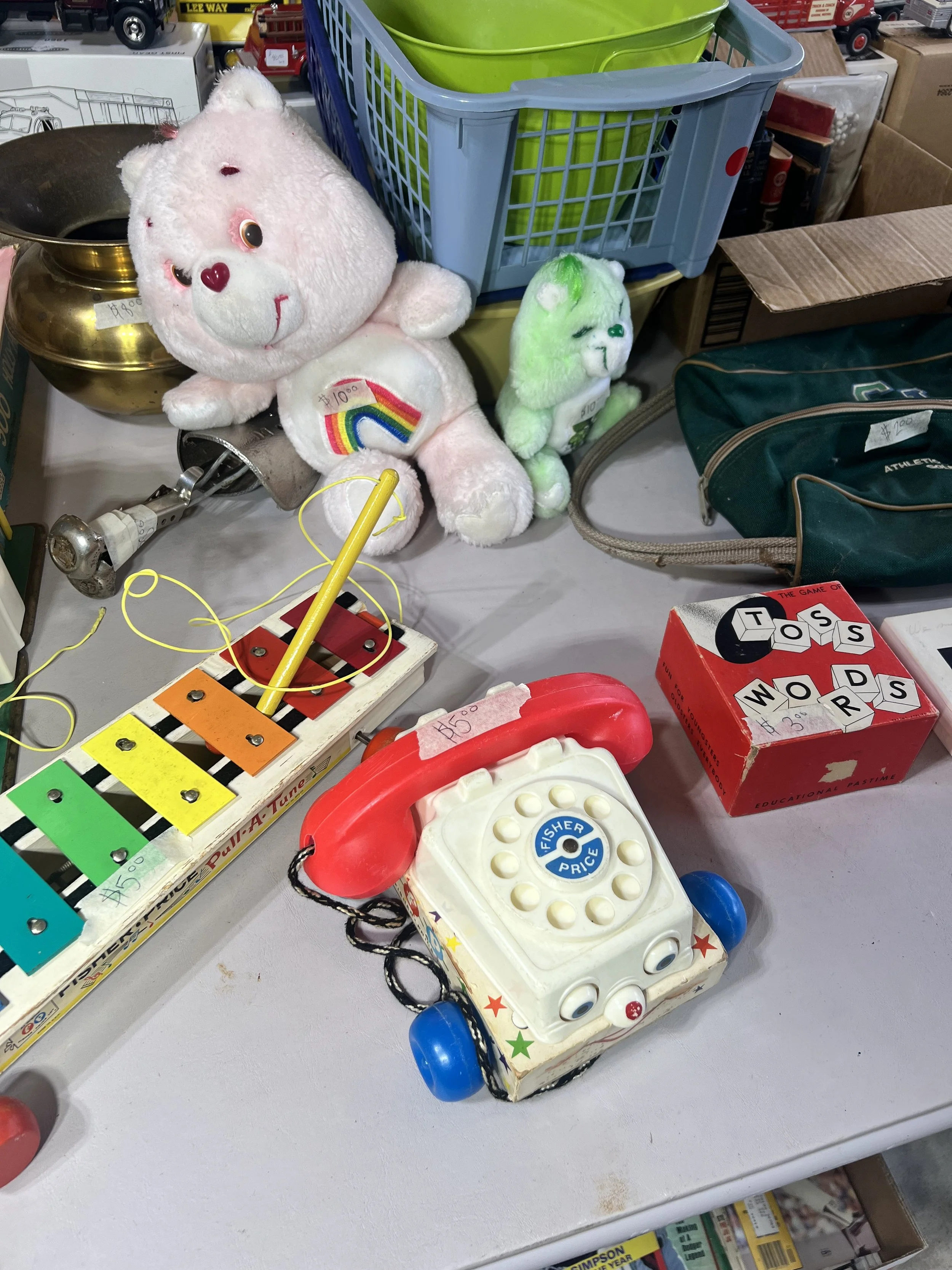 Retro Fisher-Price & Care Bears – Iconic 1980s toys including a Cheer Bear (rainbow) plush, Fisher-Price "Chatter" pull telephone, and a vintage "Pull-A-Tune" xylophone