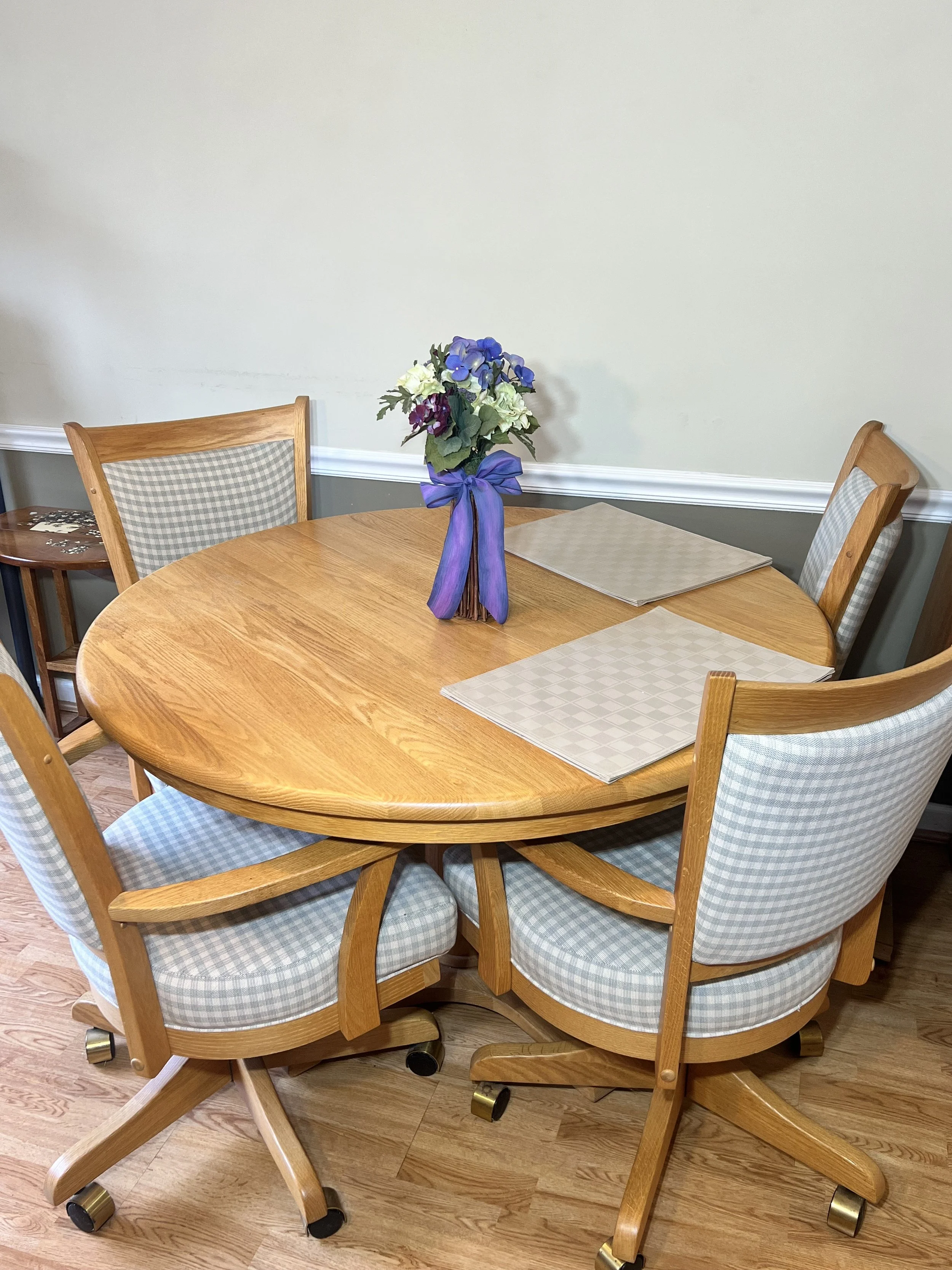 Oak Dining Suite: Round oak table with four swivel-base chairs on casters