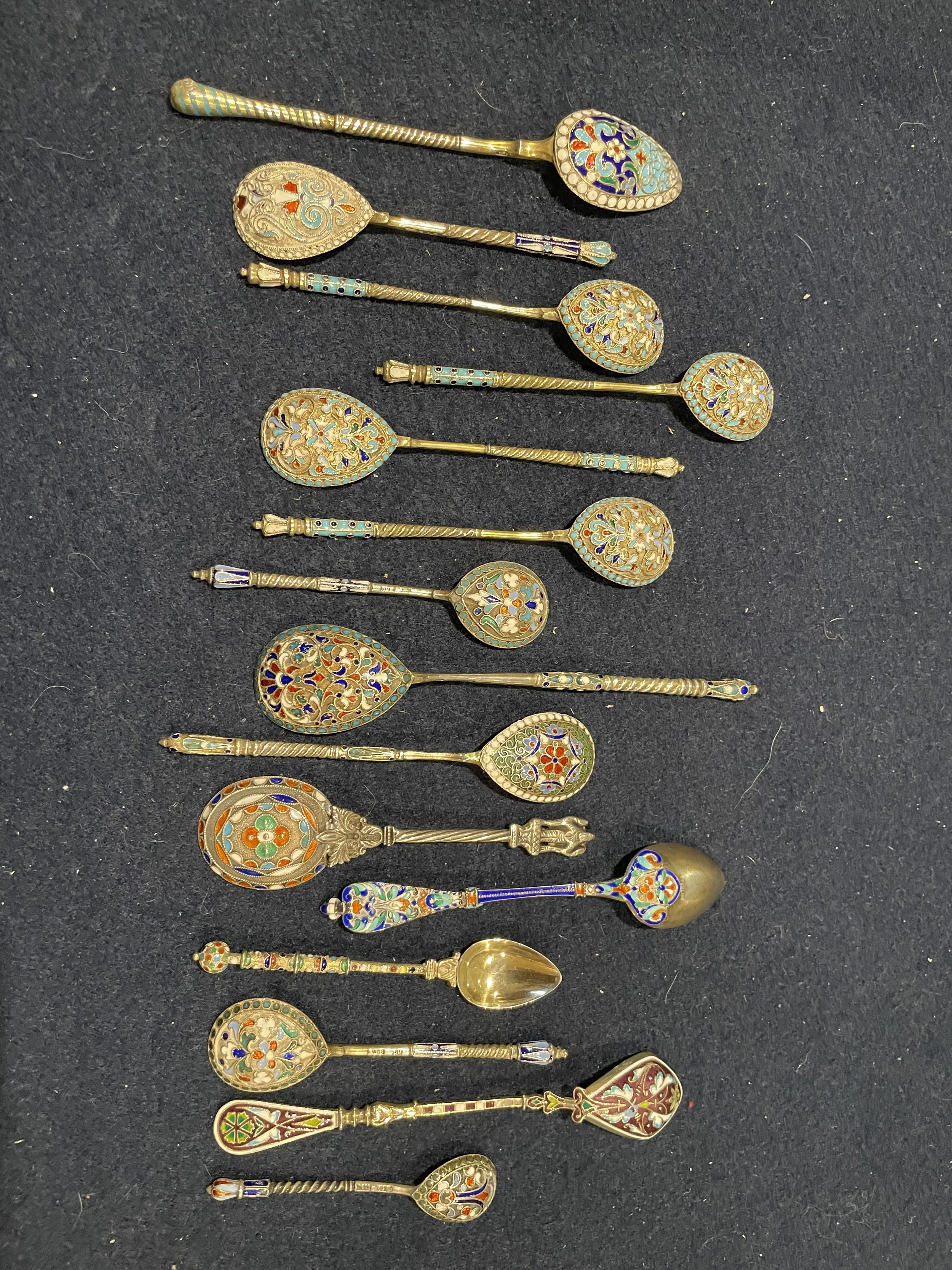 Collection of antique Russian-style cloisonné enamel spoons, featuring intricate filigree work and multi-colored floral patterns in pristine condition