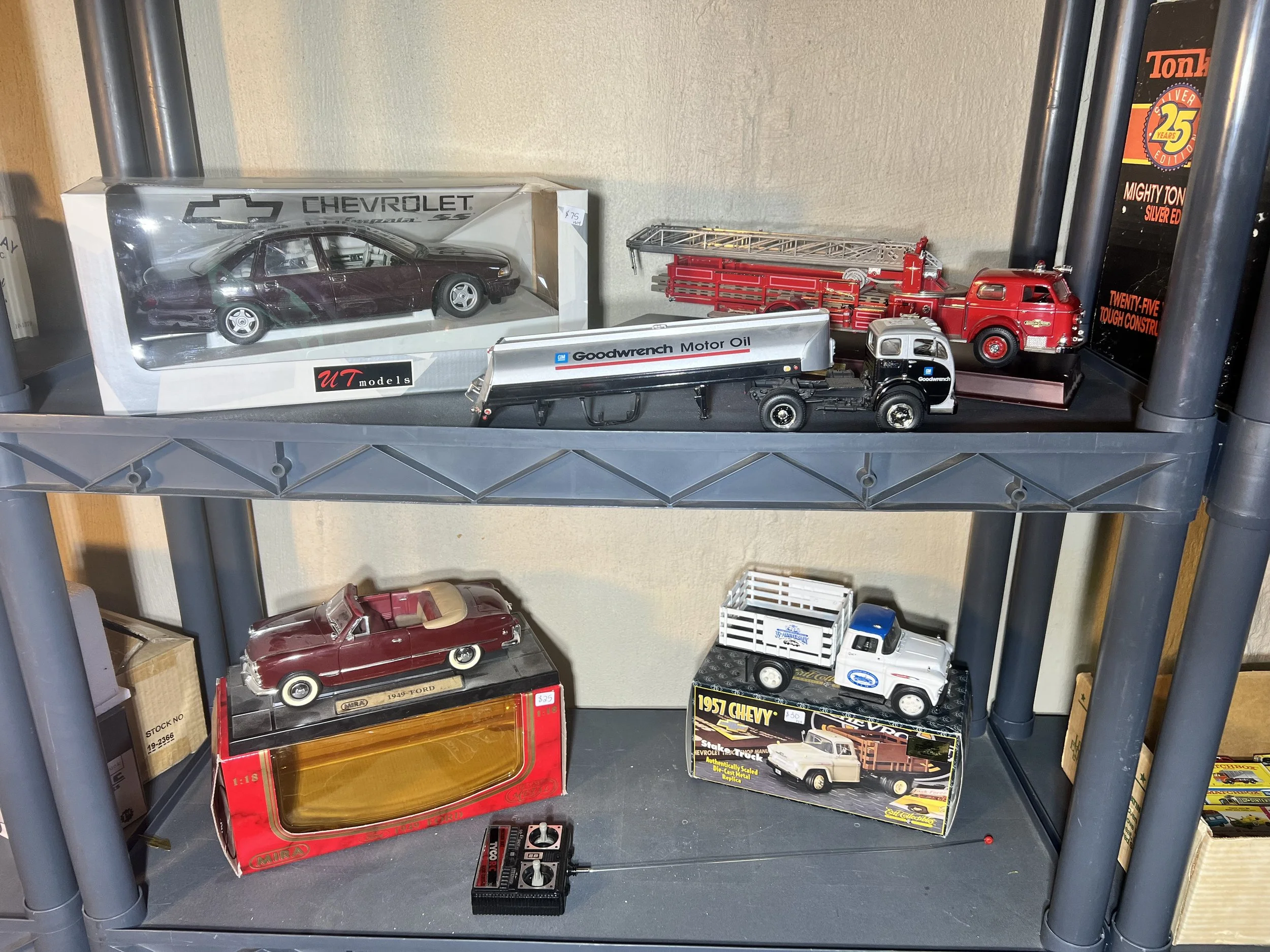 Shelving unit featuring a UT Models Chevy Impala SS and various emergency vehicles