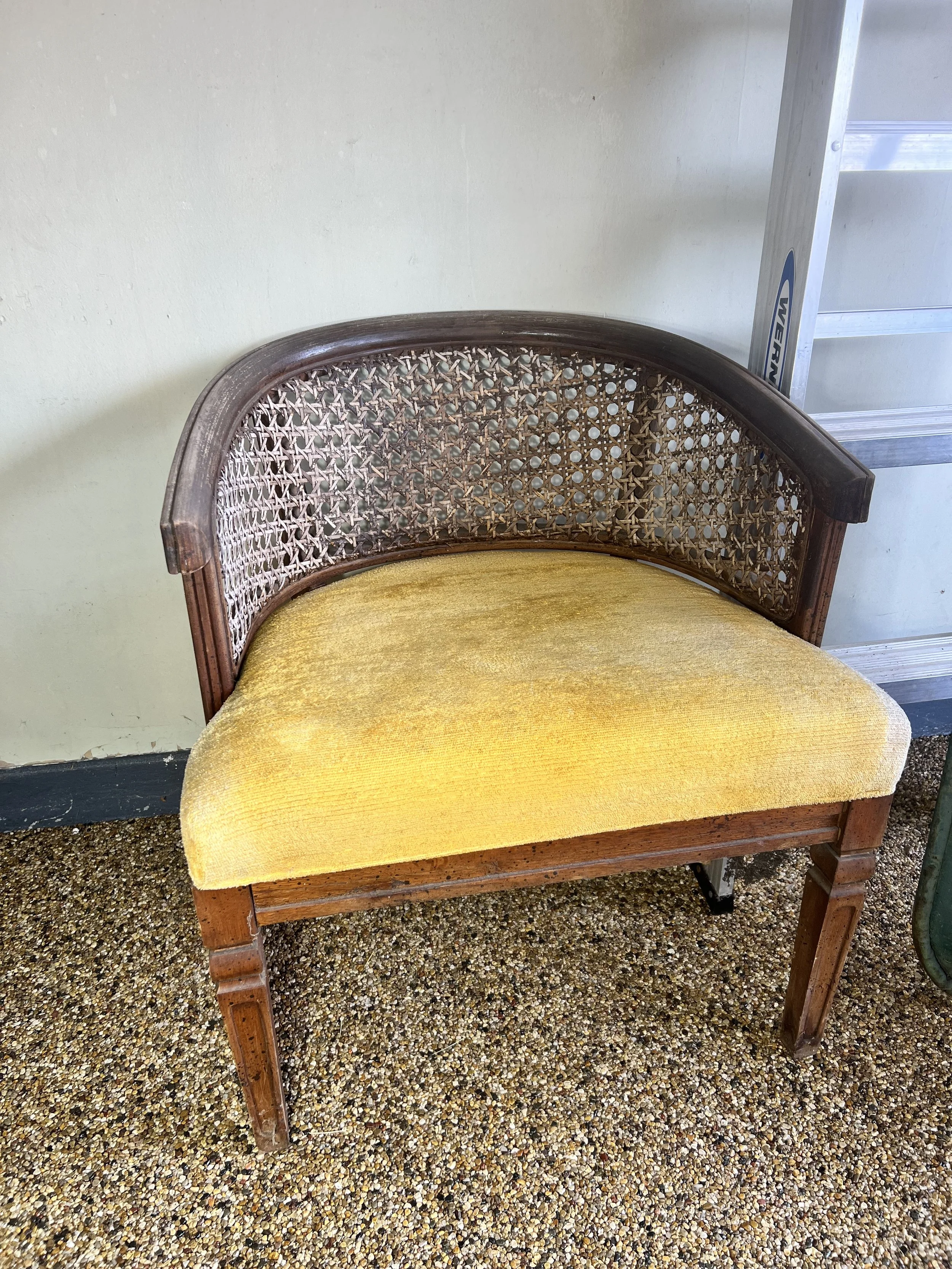 Classic wood armchair with a cane back and vibrant yellow velvet upholstered seat