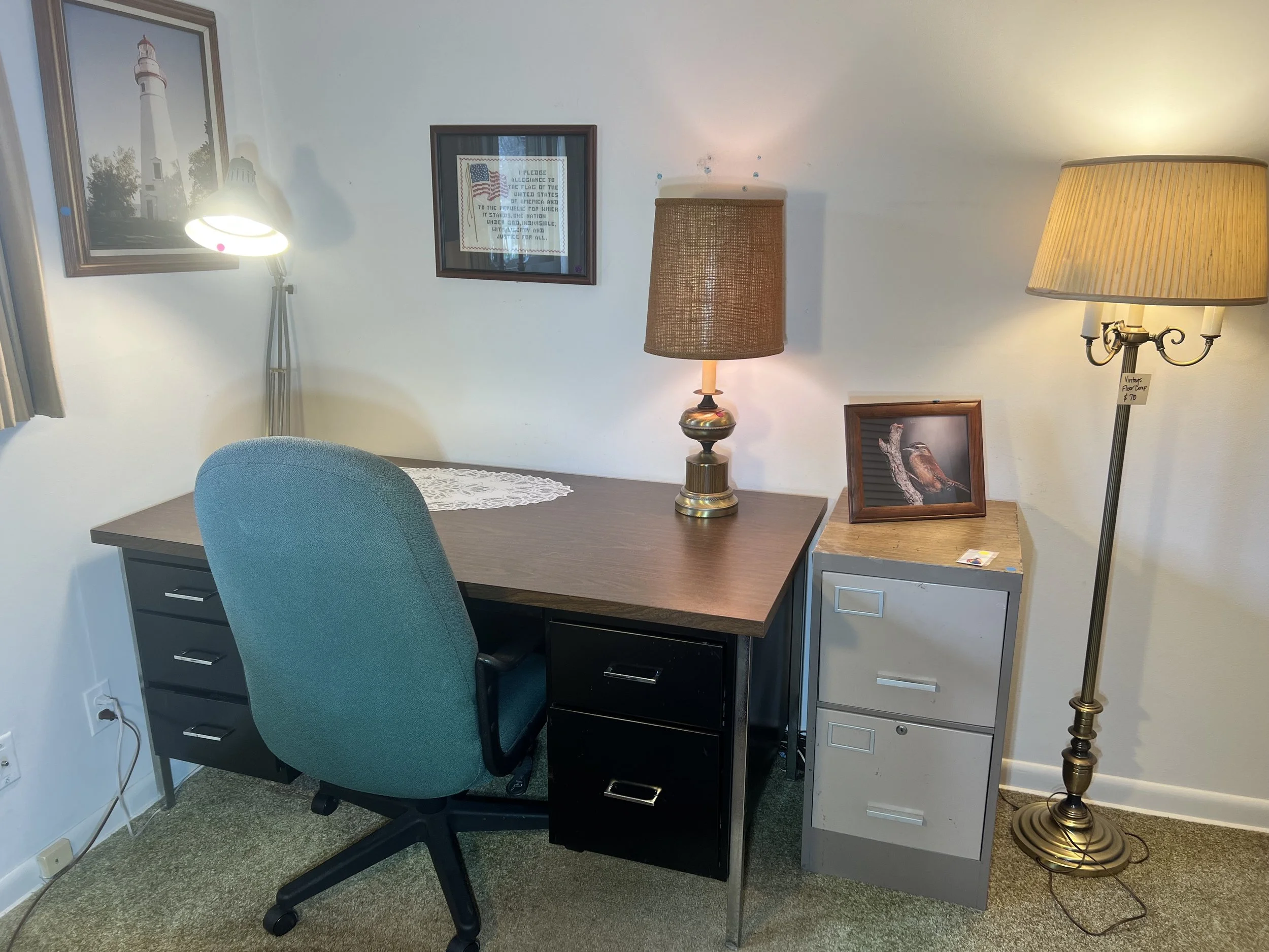 Steel-frame desk, teal rolling chair, and multi-functional lamps