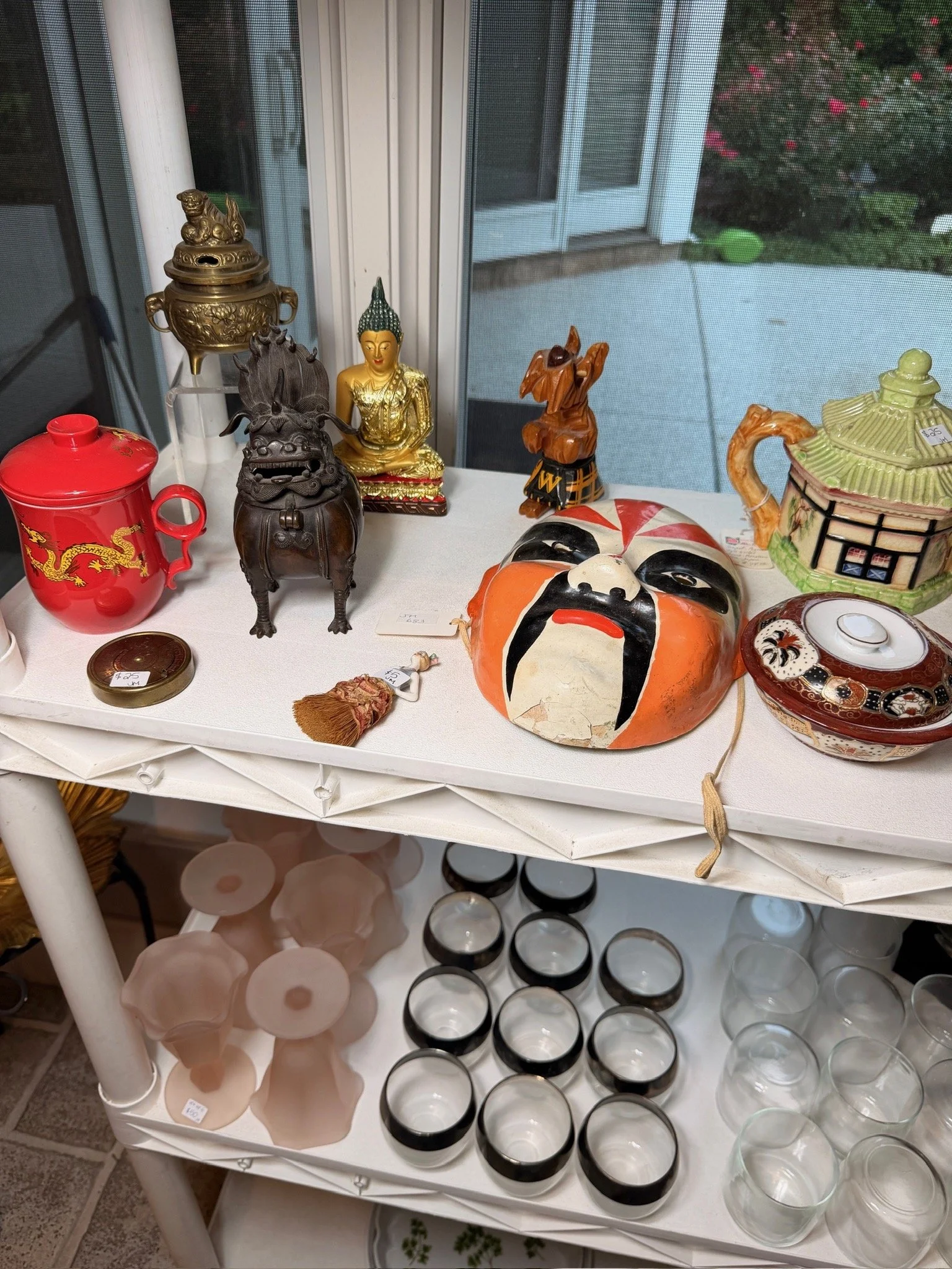 Asian-inspired decor including a bronze foo dog and mask.
