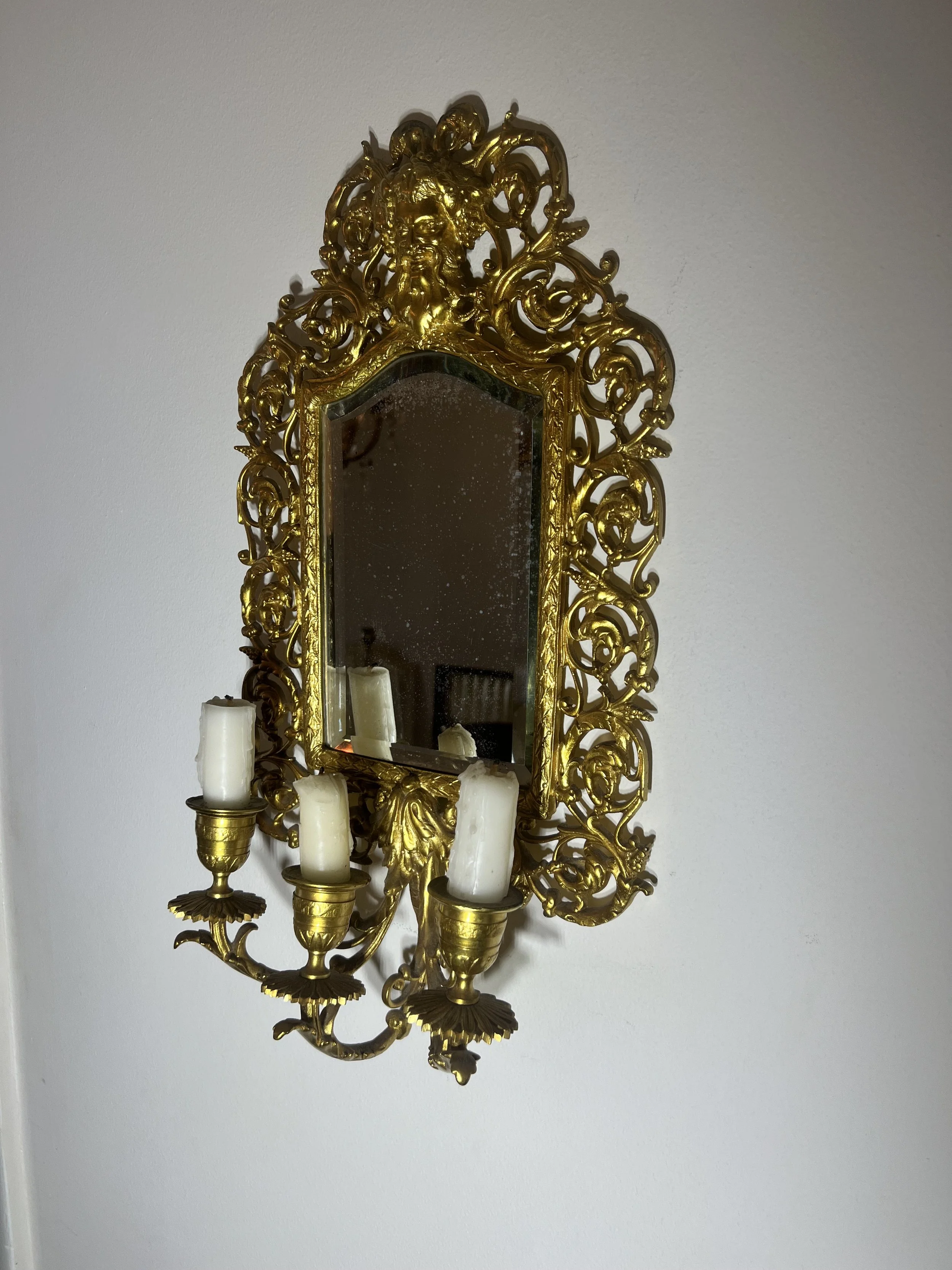 Ornate Victorian Bacchus gold-gilt mirror with an integrated triple candle sconce