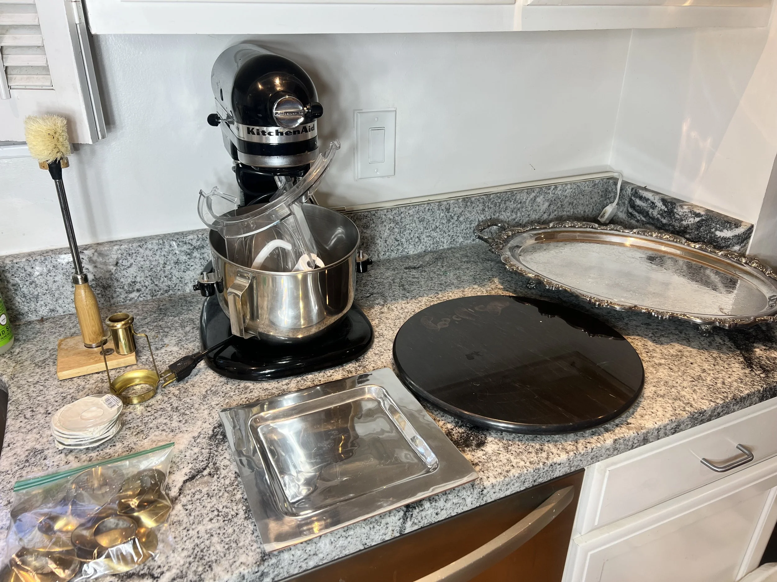 Black KitchenAid heavy-duty stand mixer with its stainless steel bowl and splash-guard attachments