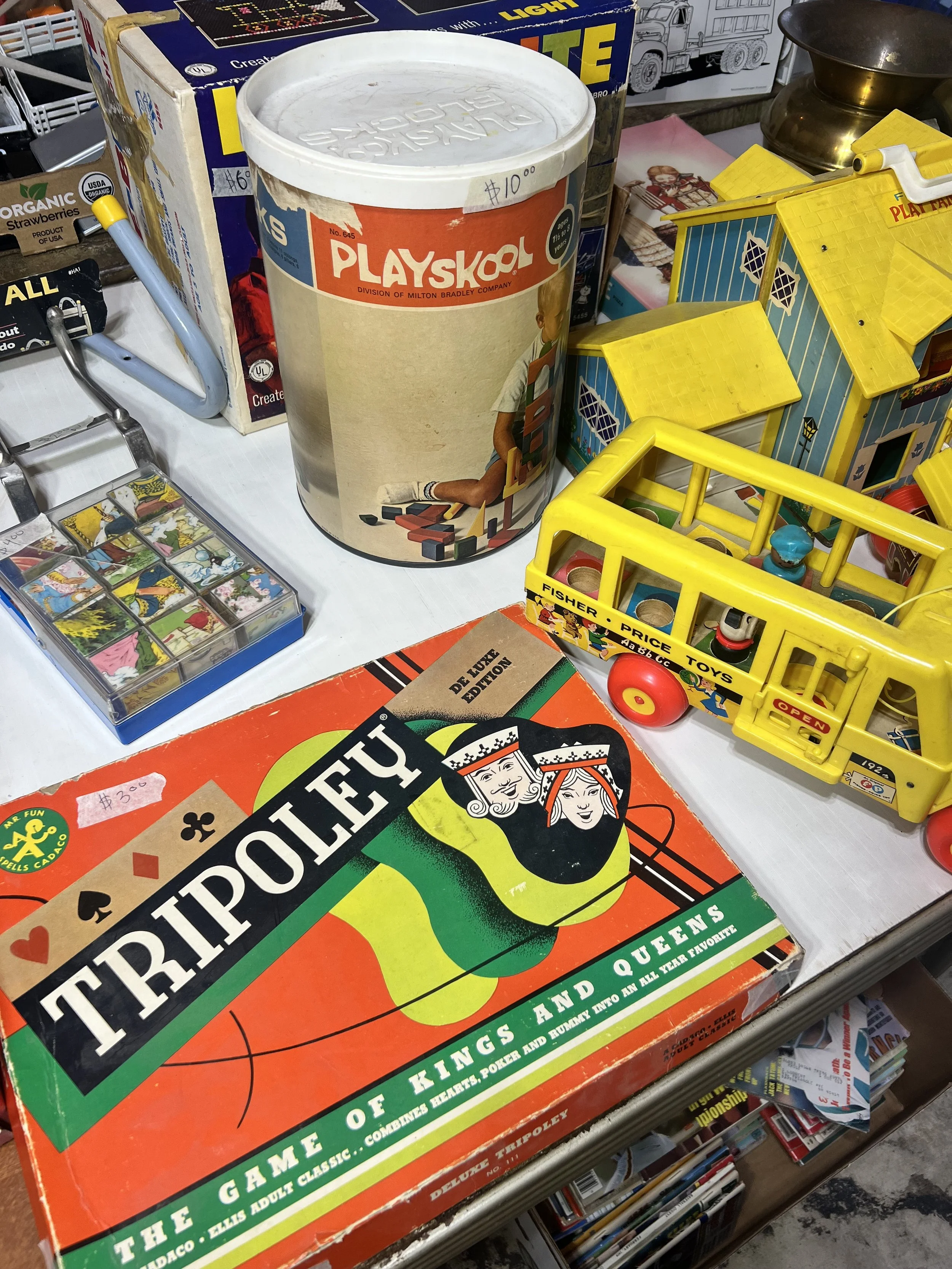 Classic Board Games & Fisher-Price – Nostalgic playtime favorites including a vintage 1960s Playskool wooden block tube, the iconic Fisher-Price School Bus, and a classic Deluxe Tripoley board game