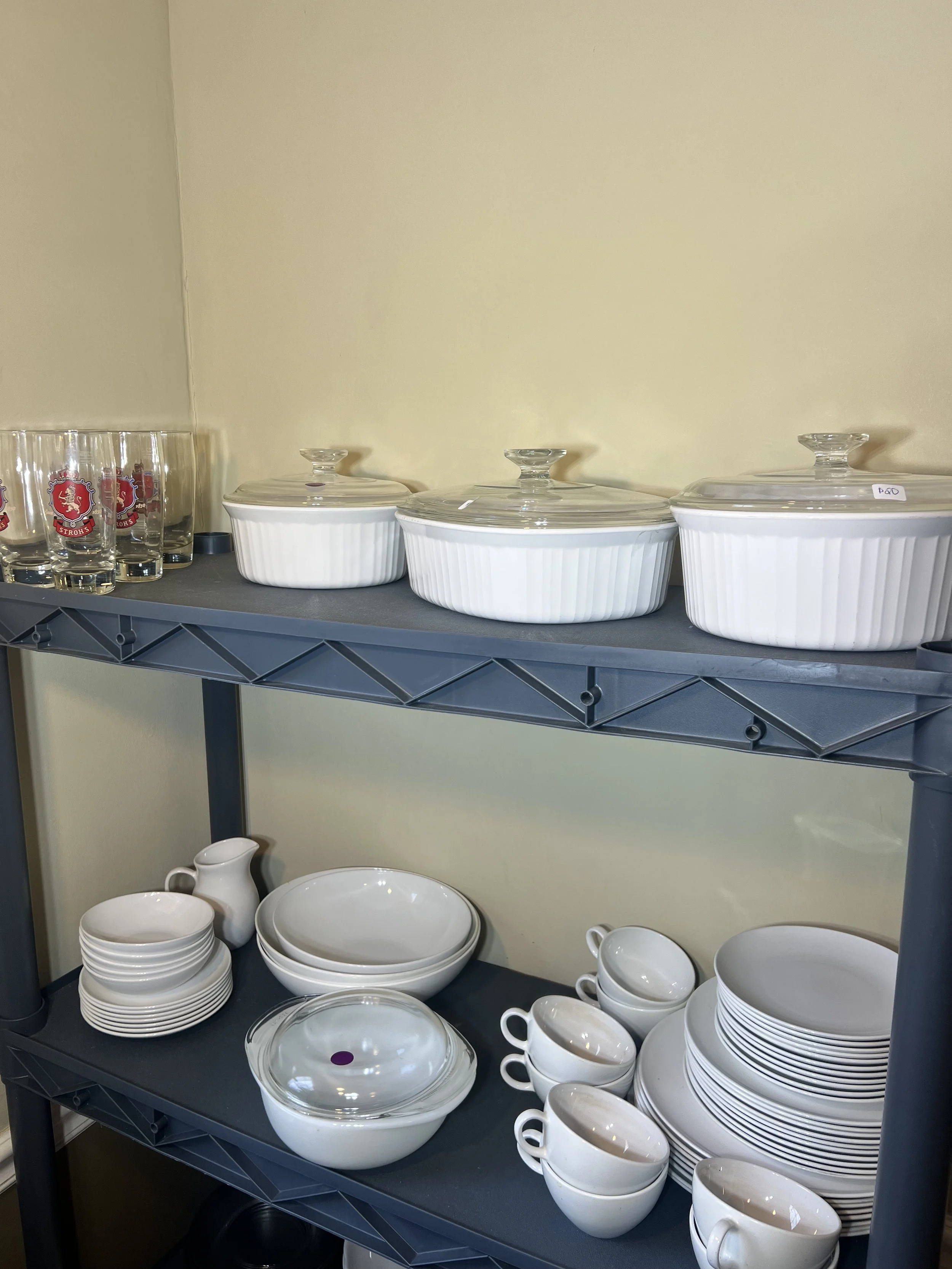 Vintage CorningWare "French White" round and oval casserole dishes with glass lids, and a white ceramic dinnerware set