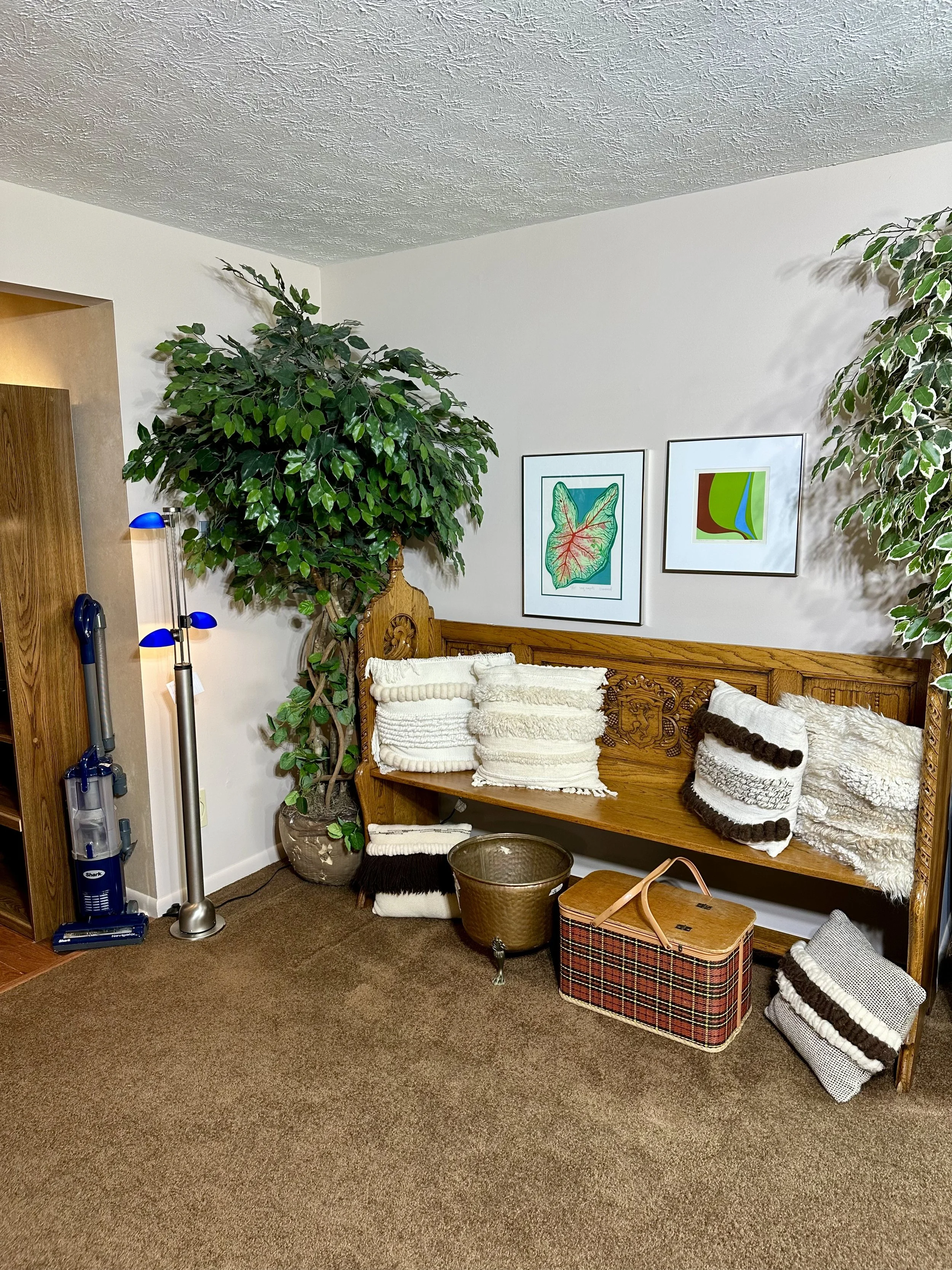 Antique church pew, decorative pillows, decorative trees