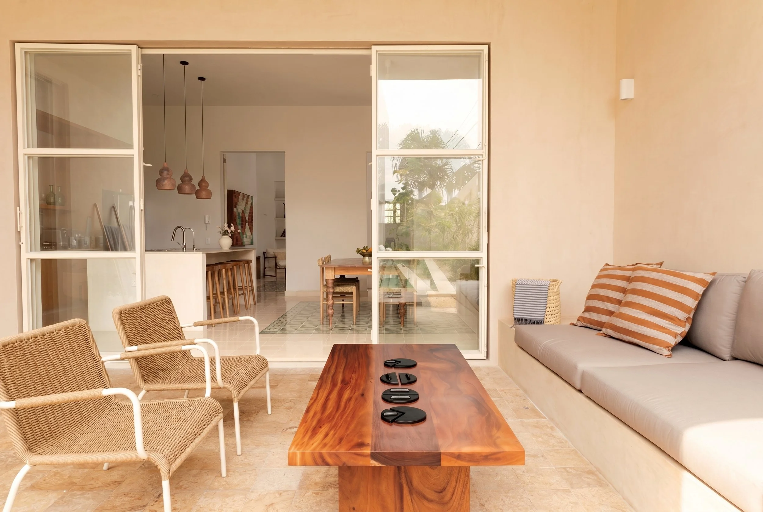 View from outdoor living toward kitchen and living room with restored original pasta tiles at Casa Goliana by Laseu Studio