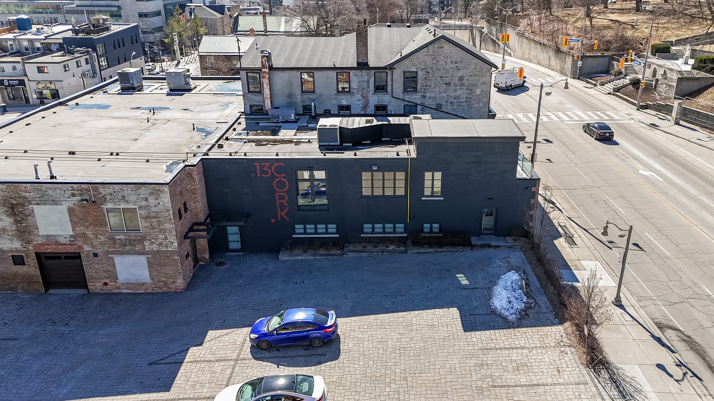 Aerial view of the building roofline, parking area and street corner, downtown Guelph