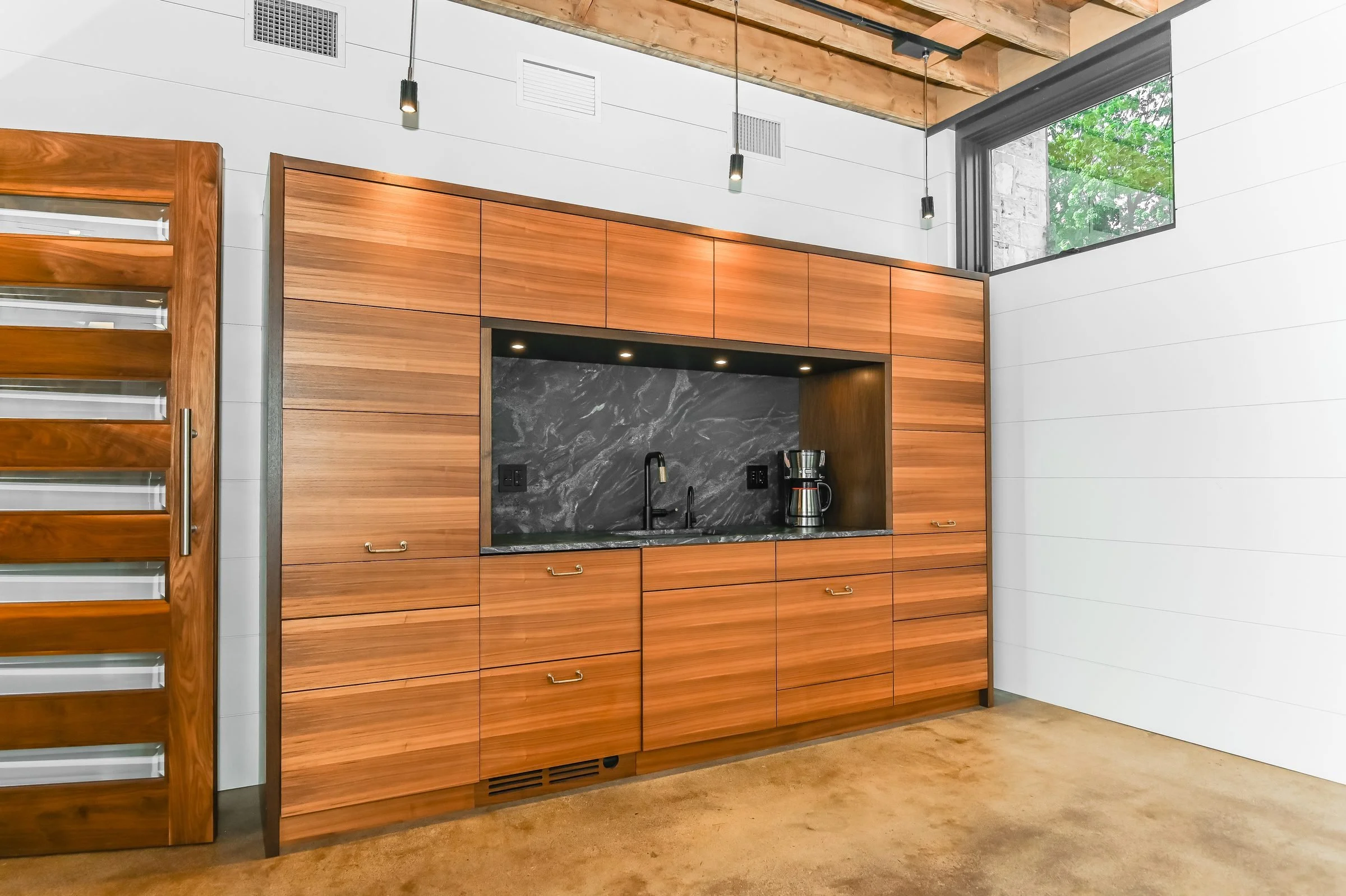 Kitchenette with wood millwork and stone backsplash, Unit 200, 13 Cork Street East