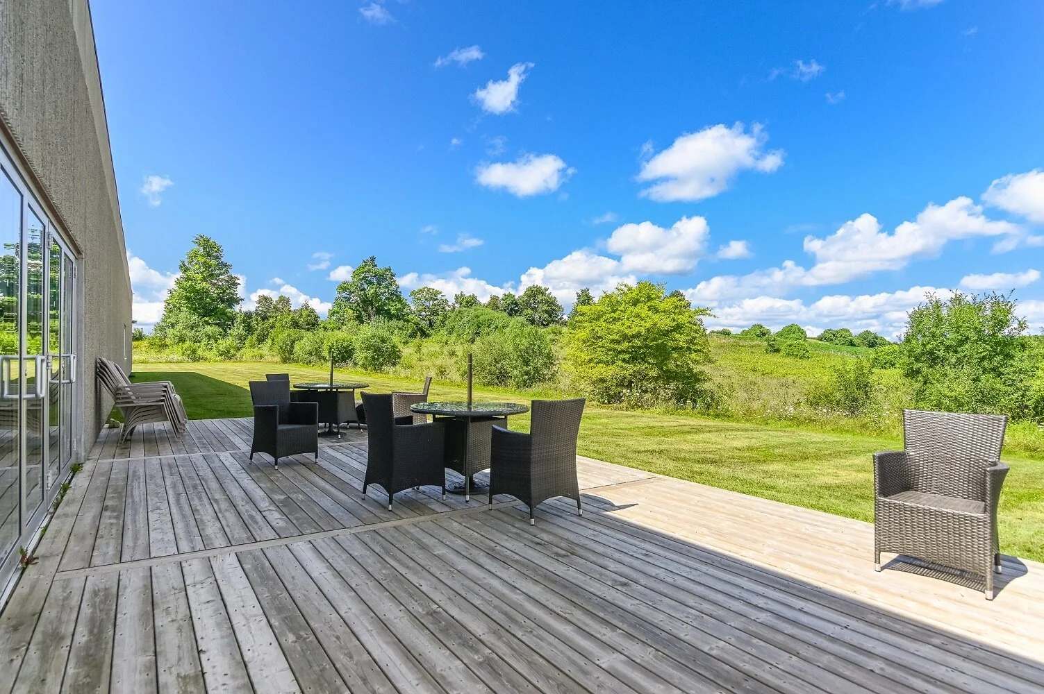 Rear wood deck with patio furniture and open fields beyond at 546 Governors Road