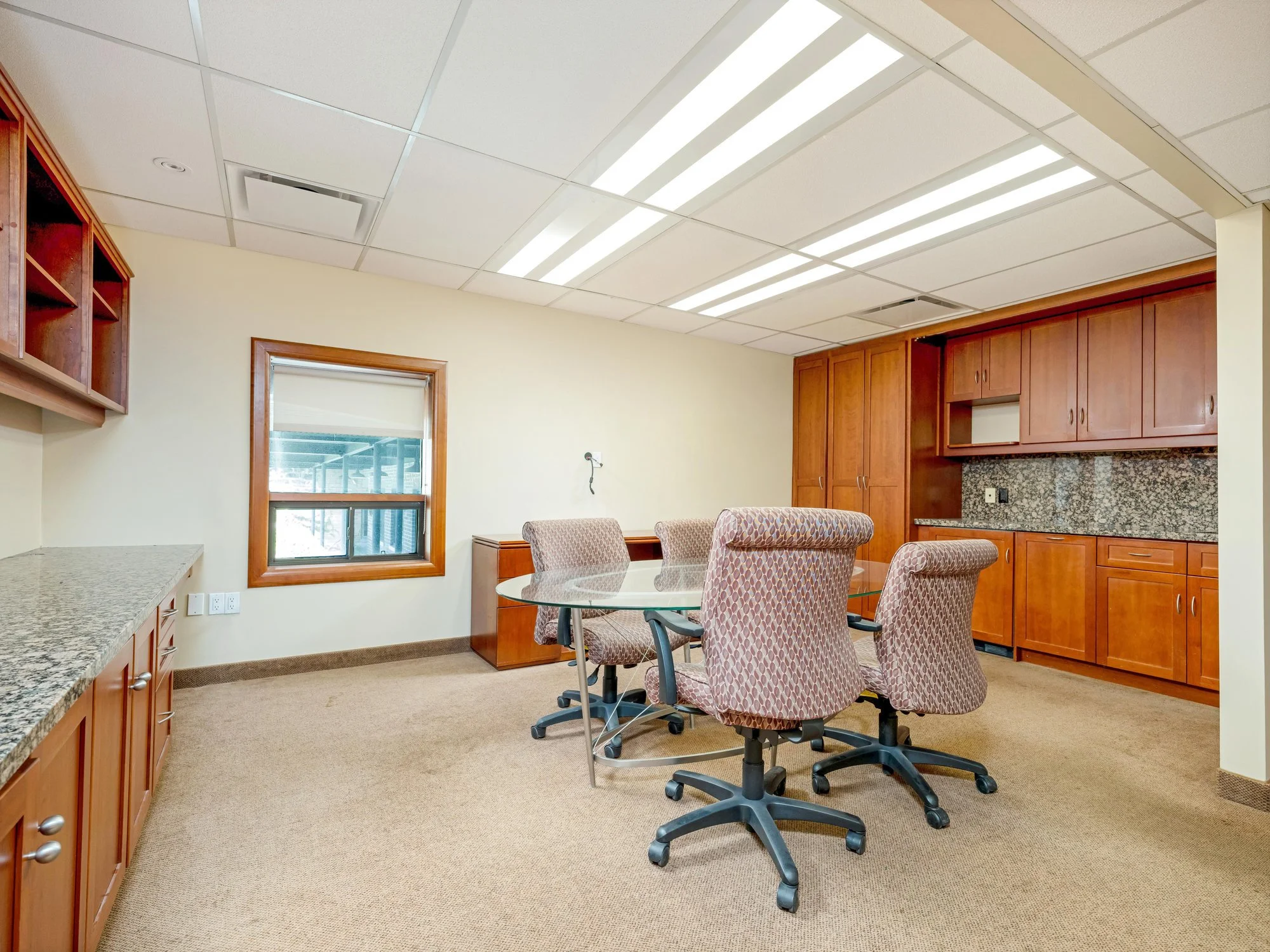 Meeting room with round table and cherry cabinetry