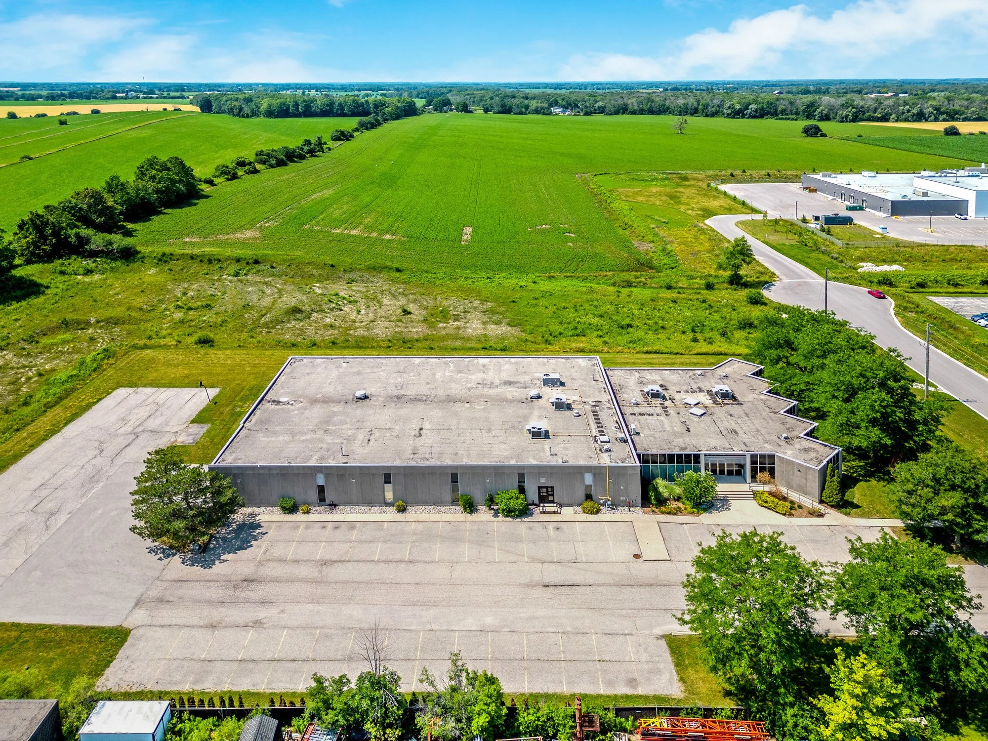 Aerial view of the building and parking lot with farmland beyond