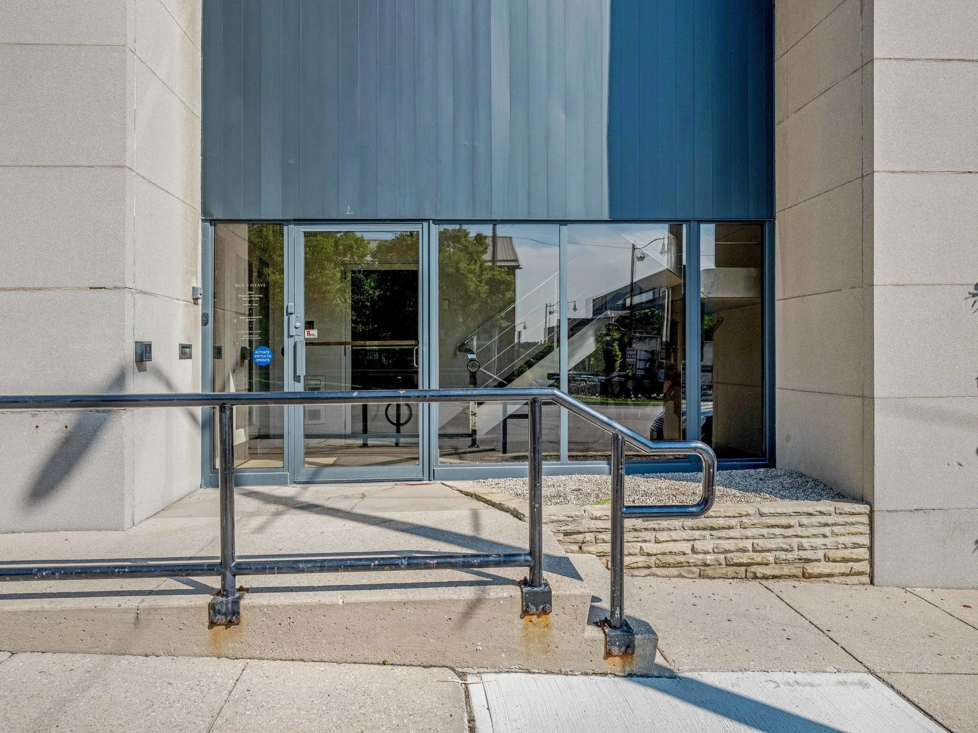 Glass entrance doors at 8 Macdonell Street behind a metal handrail