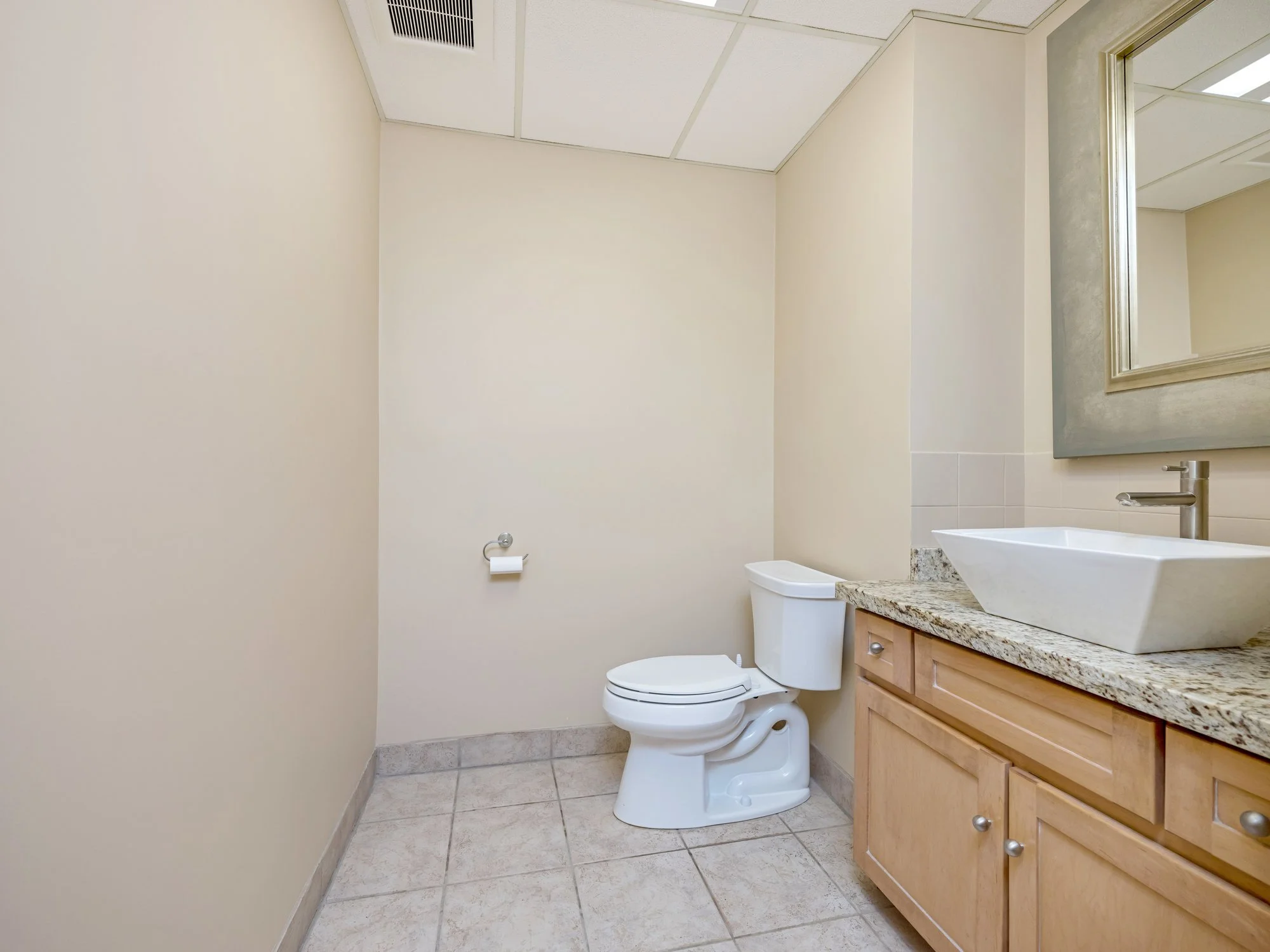 Washroom with granite vanity and tile floor