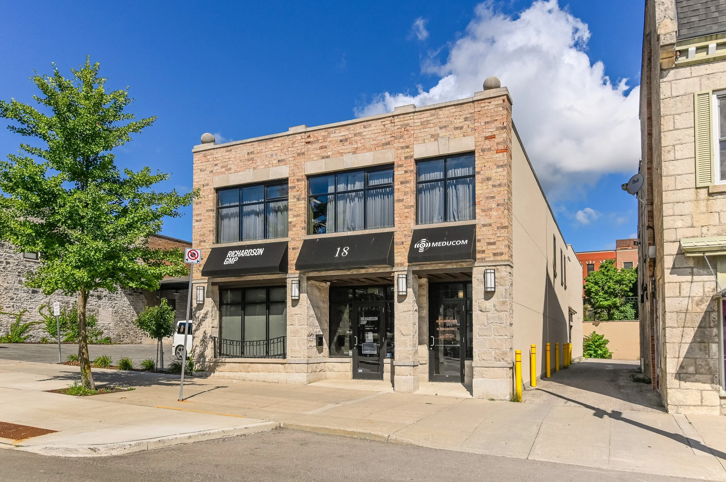 Front of 18 Macdonell Street with black awnings and ground-floor storefront windows