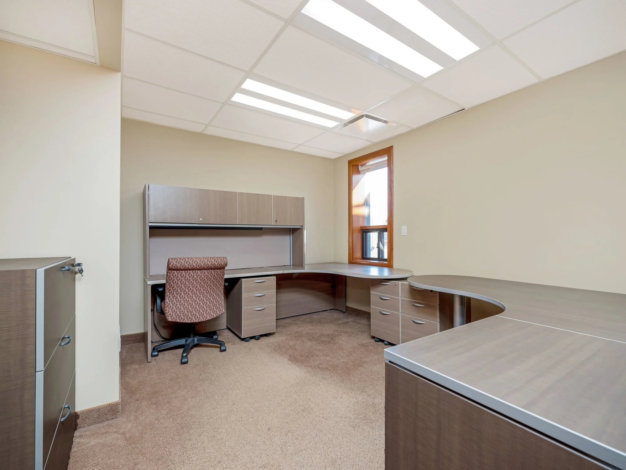 Office workstation with a gray desk, cabinets and a task chair