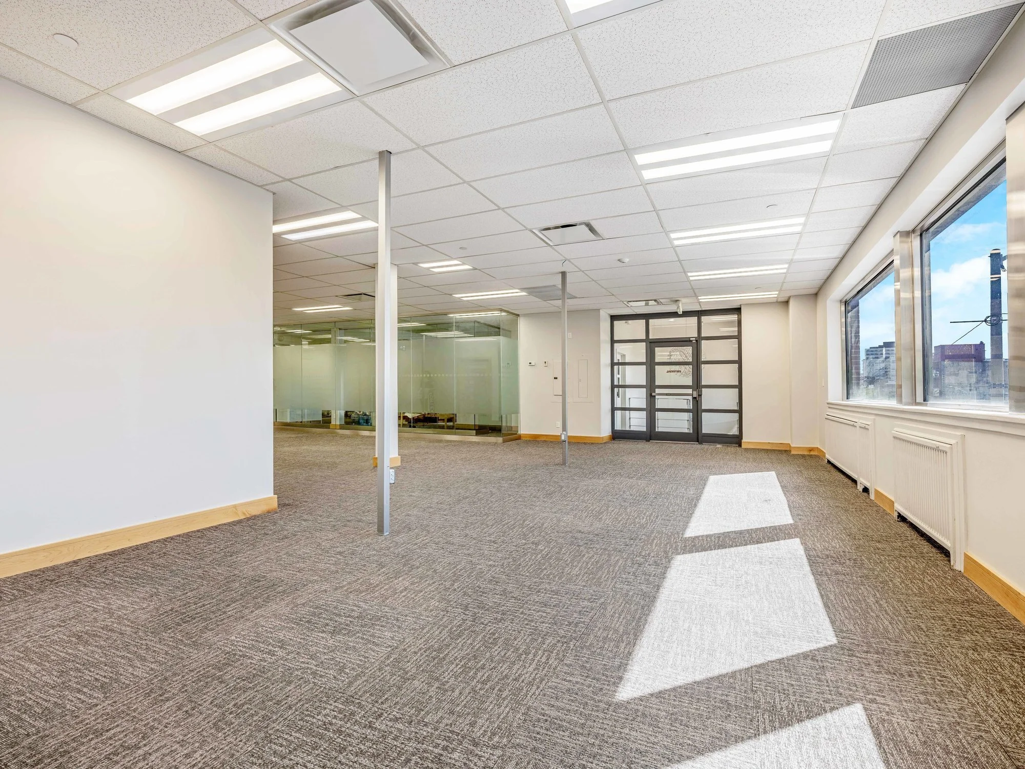 Open office floor in Unit 200A looking toward the glass entry doors