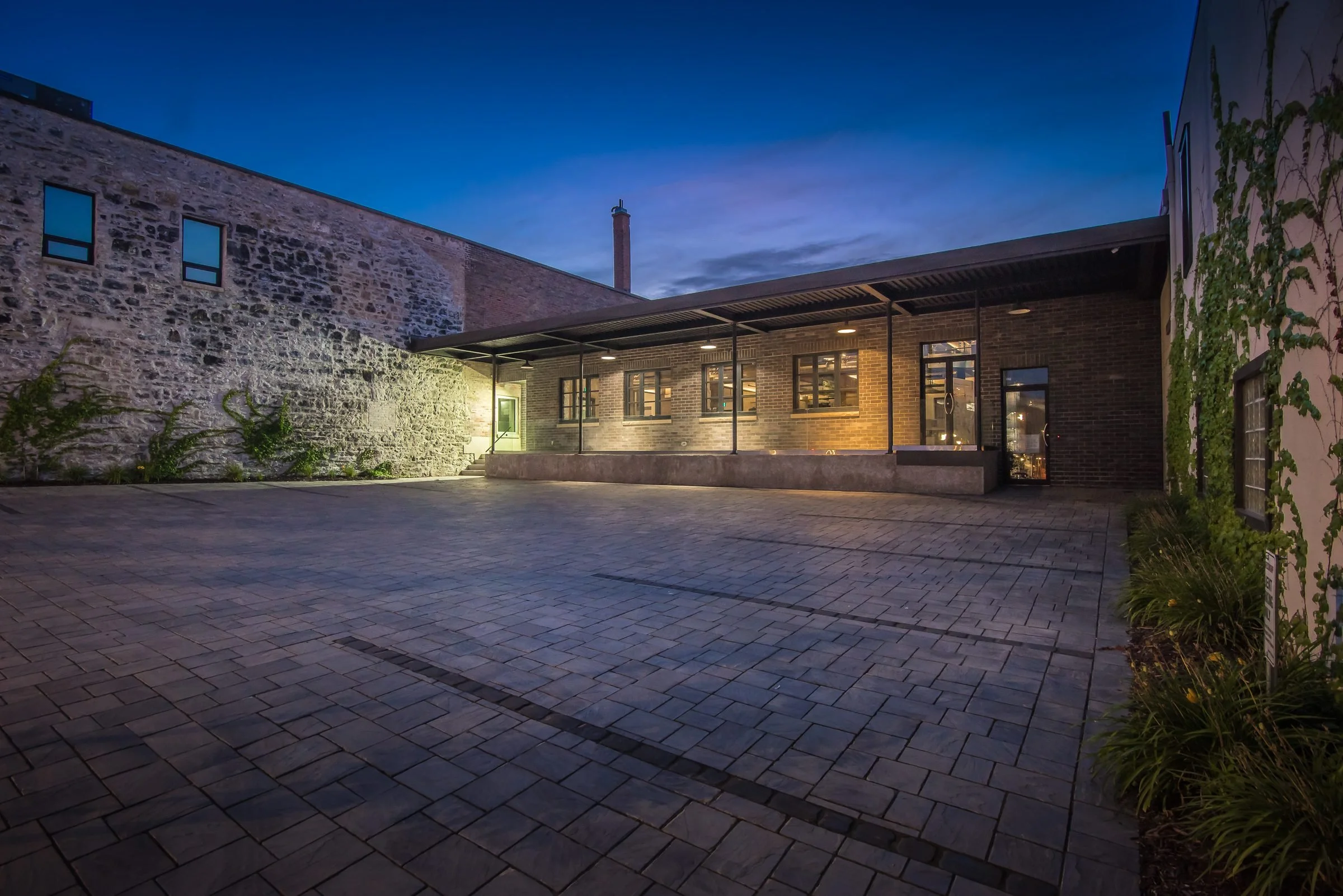 Courtyard behind the Guelph Mercury Building at dusk with lit windows
