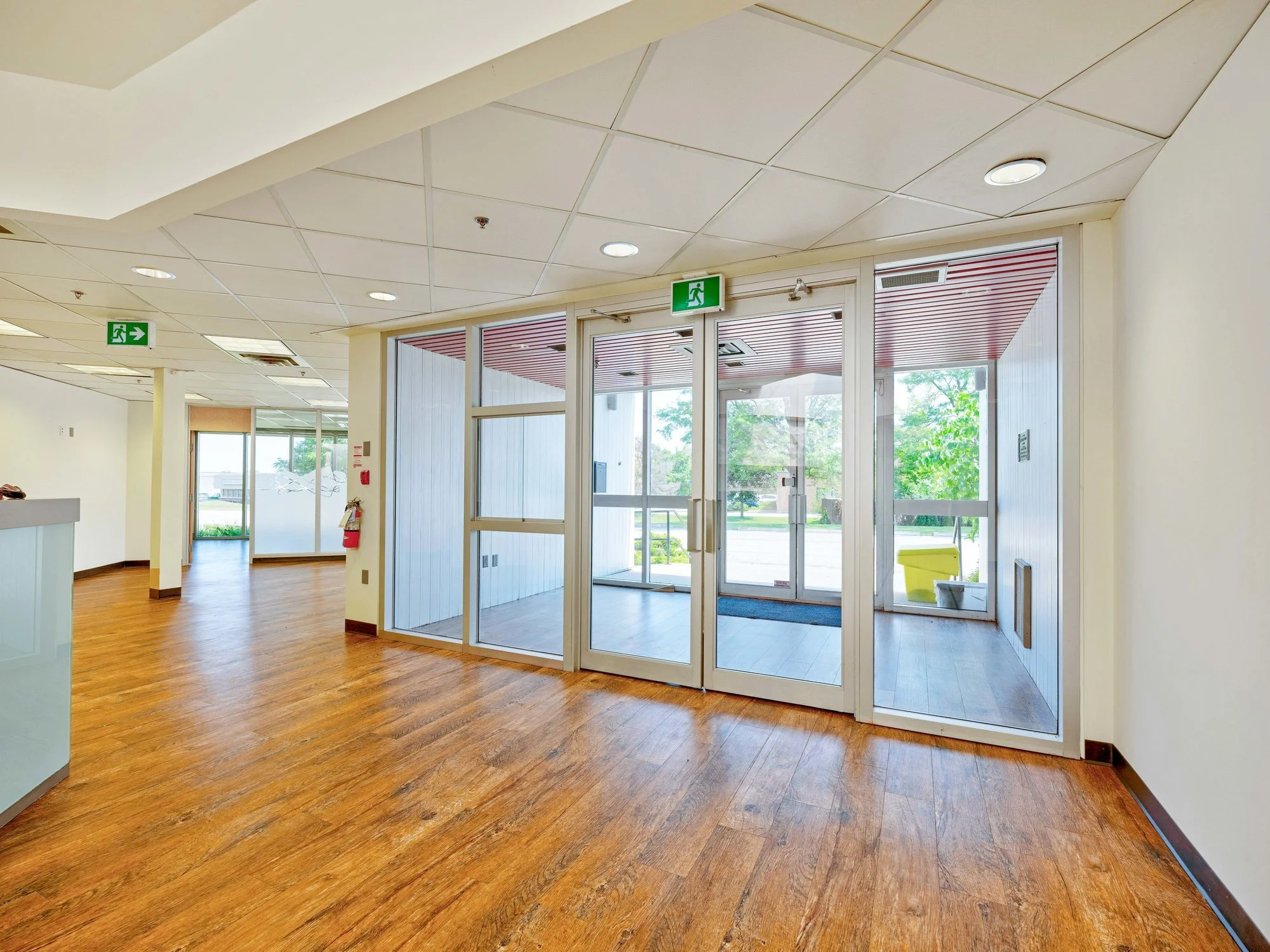 Bright open lobby with glass doors and wood floors