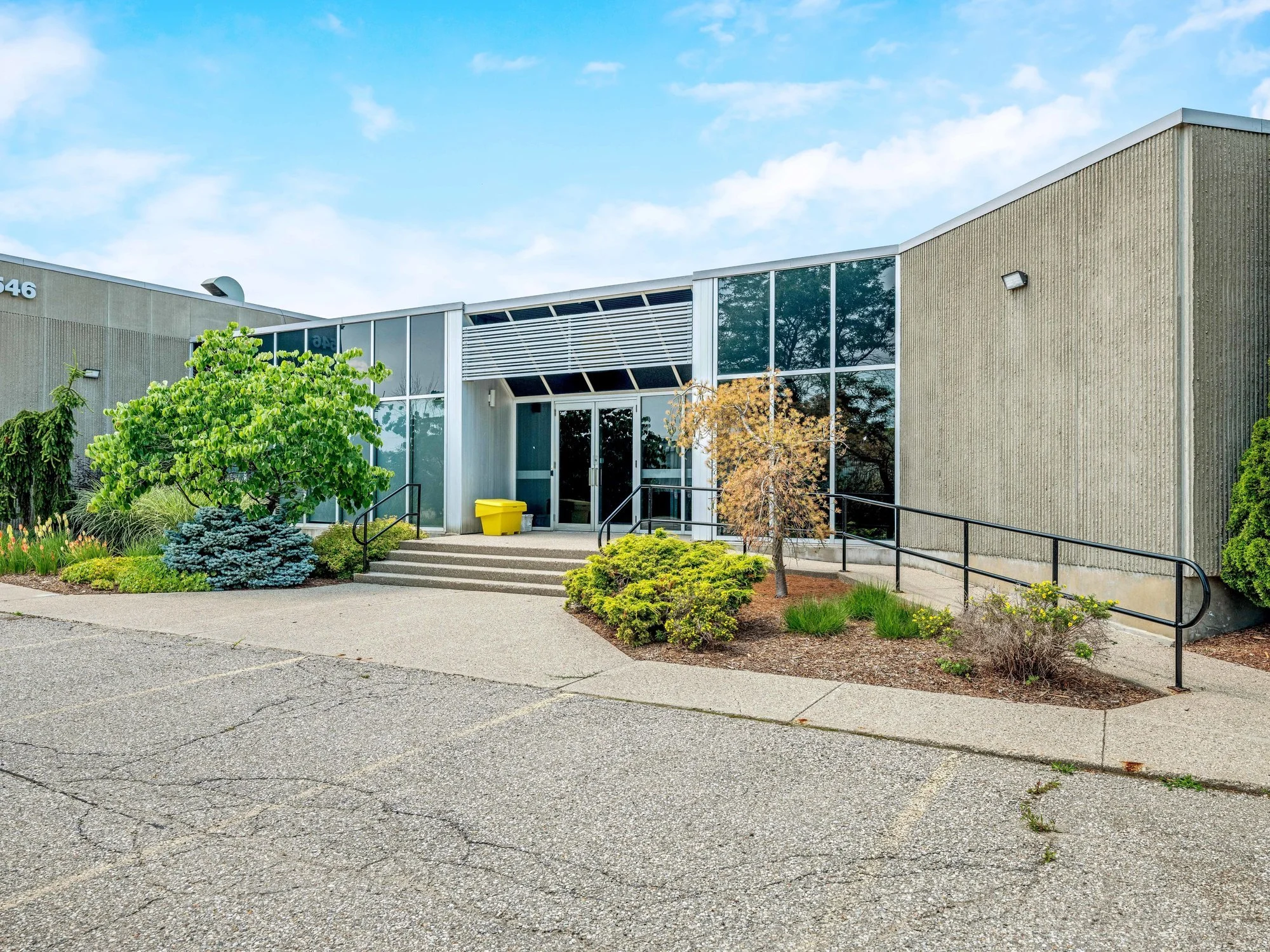 Front of 546 Governors Road with a glass and concrete office entrance and landscaped walkway