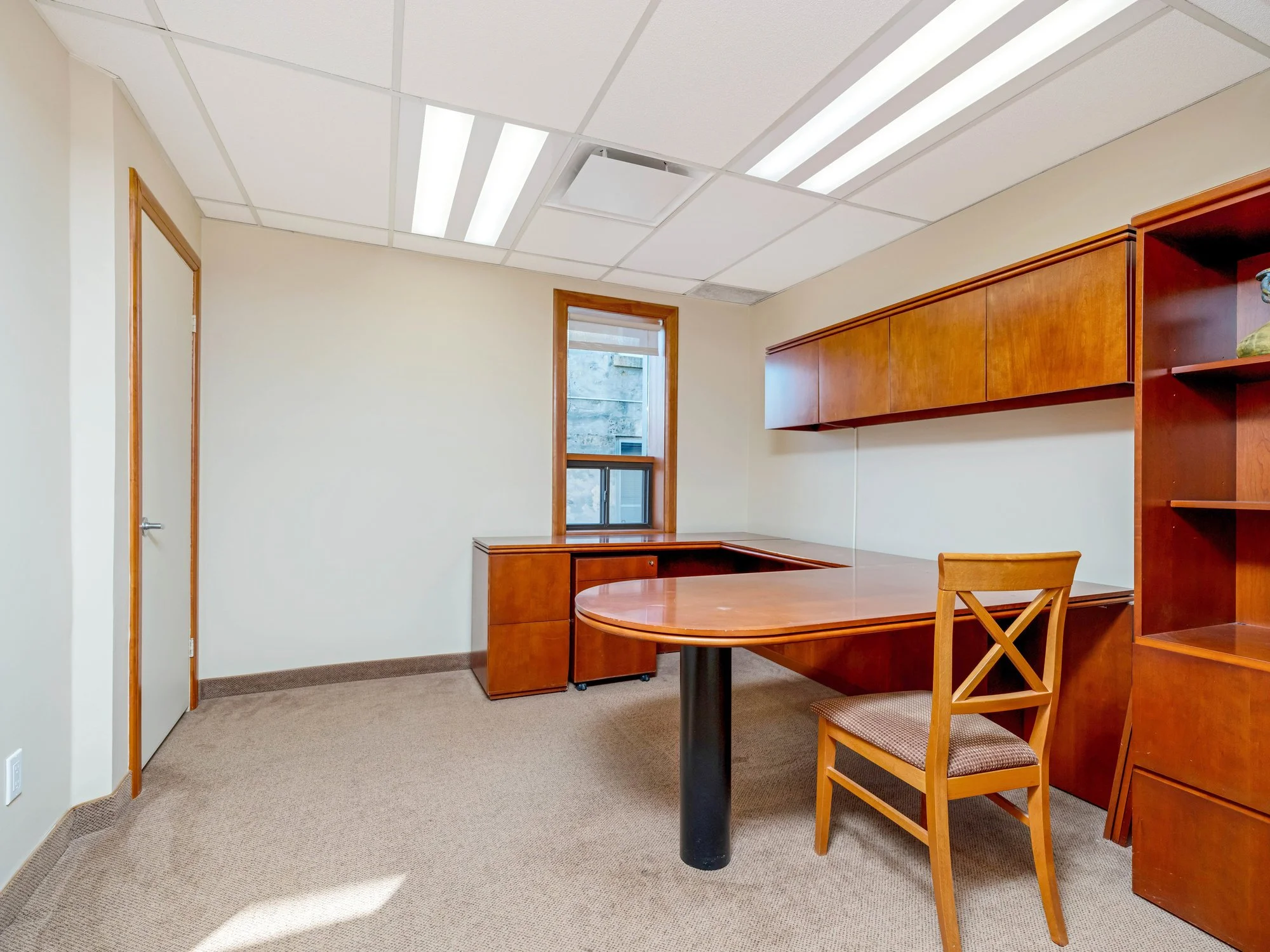 Private office with a wood desk, chair and built-in shelving