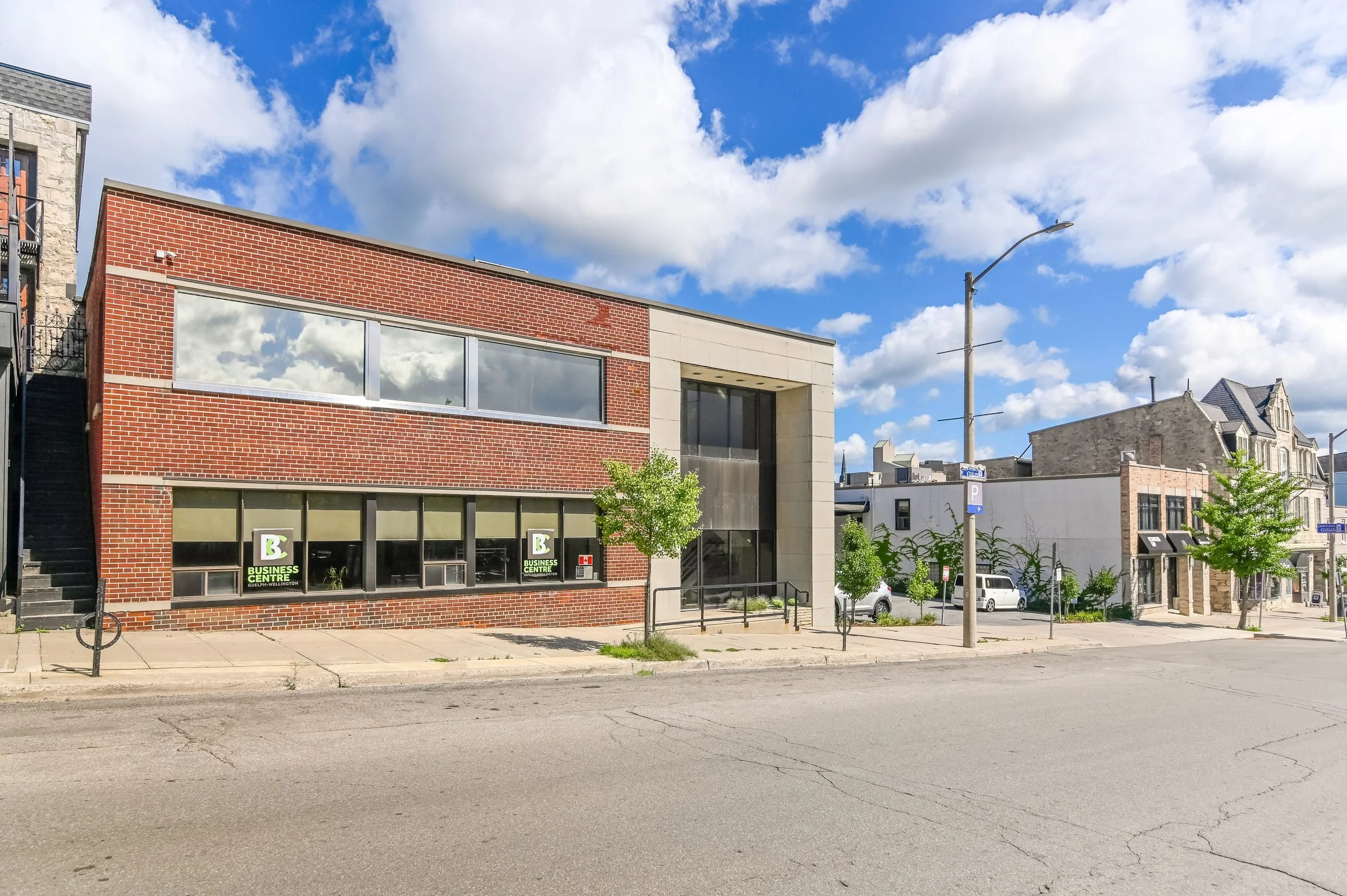Red brick and limestone facade of the Guelph Mercury Building on a street corner