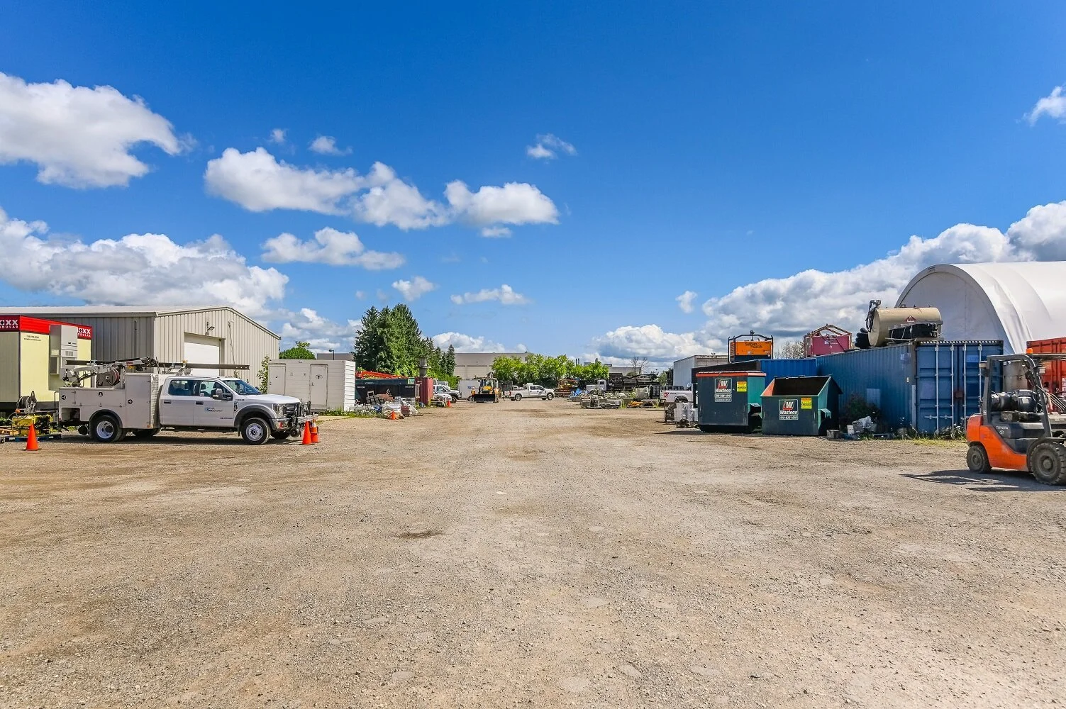 Rear yard at 455 Silvercreek Parkway North with trucks and equipment