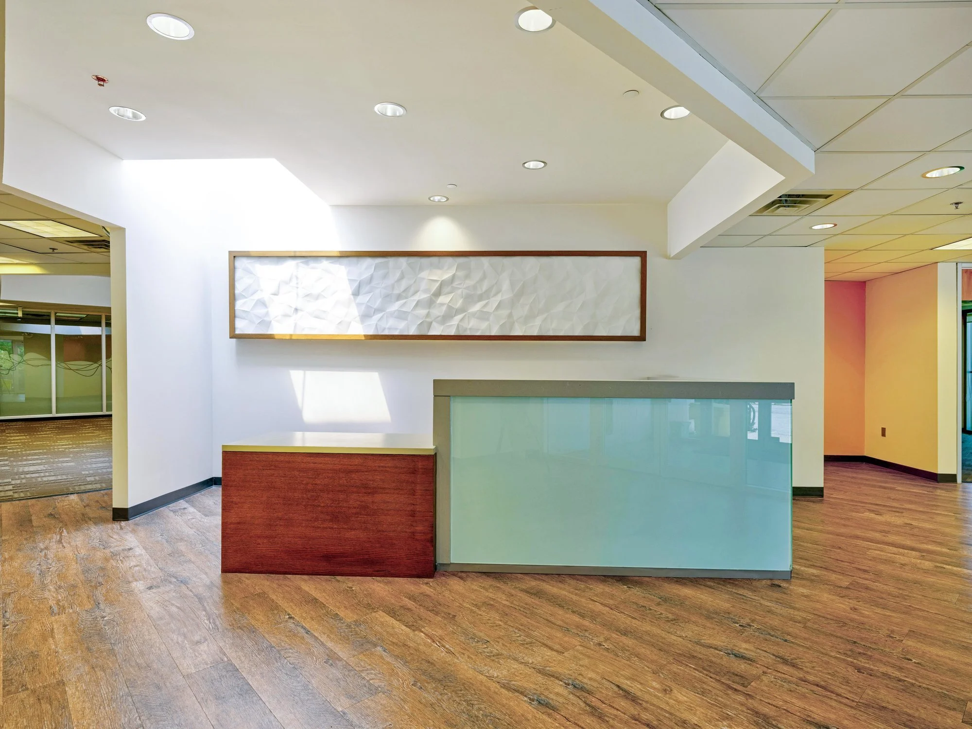 Reception desk with frosted glass front and wood floor