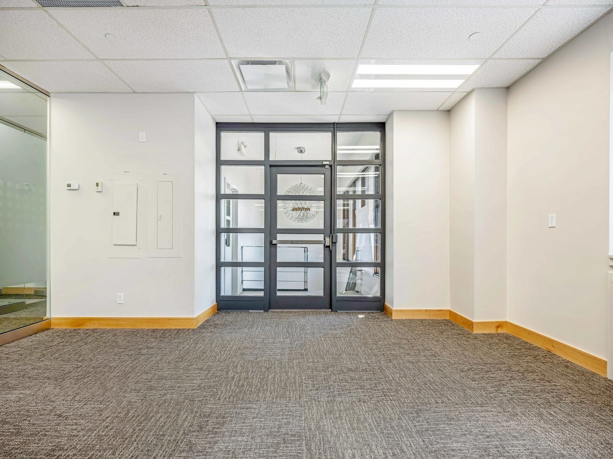 Carpeted reception area in Unit 200A with glass double doors at the far wall
