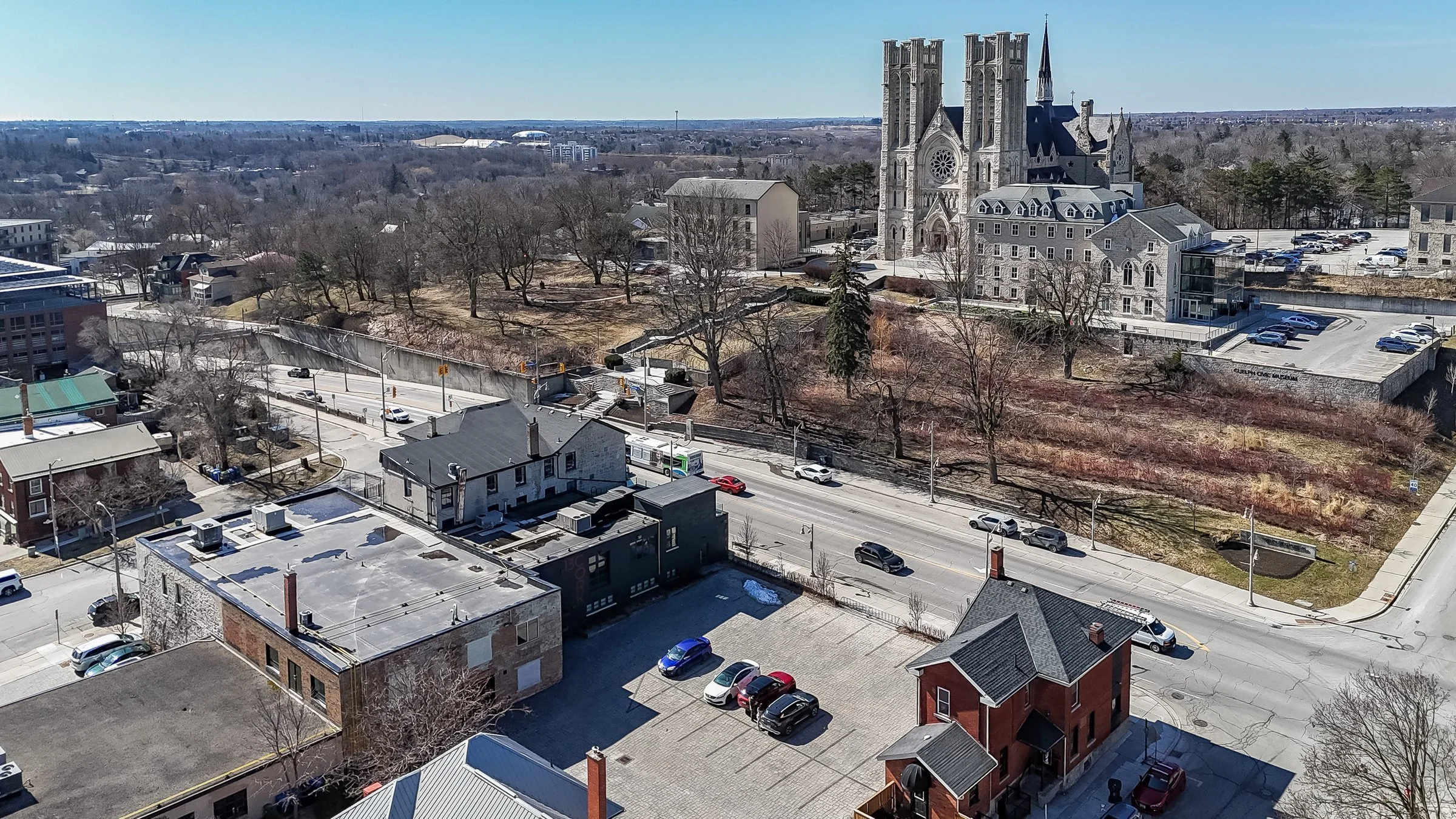 Aerial view of downtown Guelph streets and a parking lot with the cathedral on the skyline