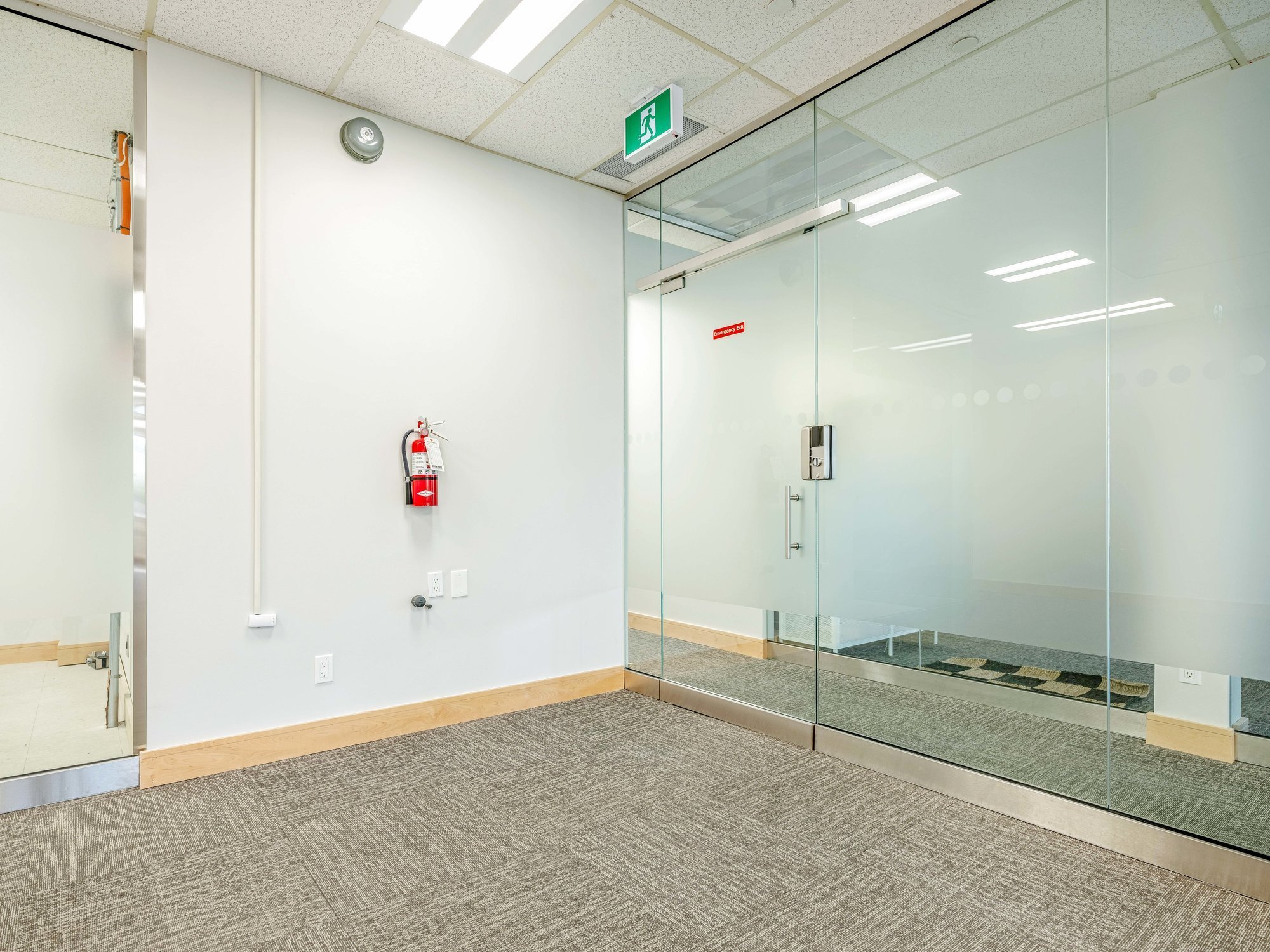 Frosted glass offices and a fire extinguisher along the wall in Unit 200A