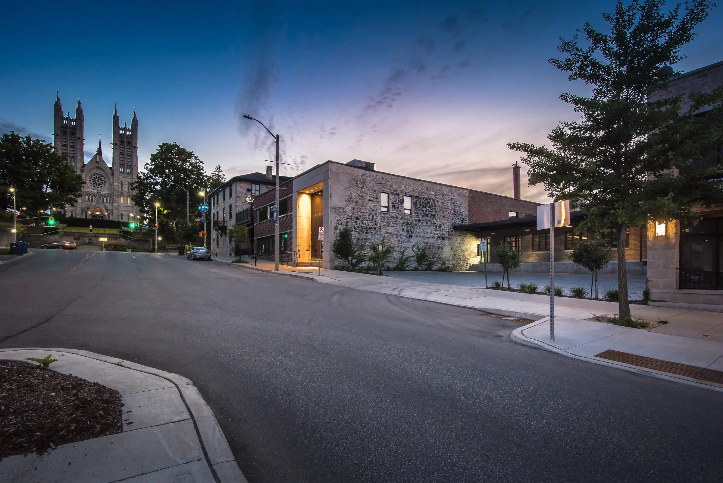 Guelph Mercury Building at dusk on Macdonell Street with a church spire in the background