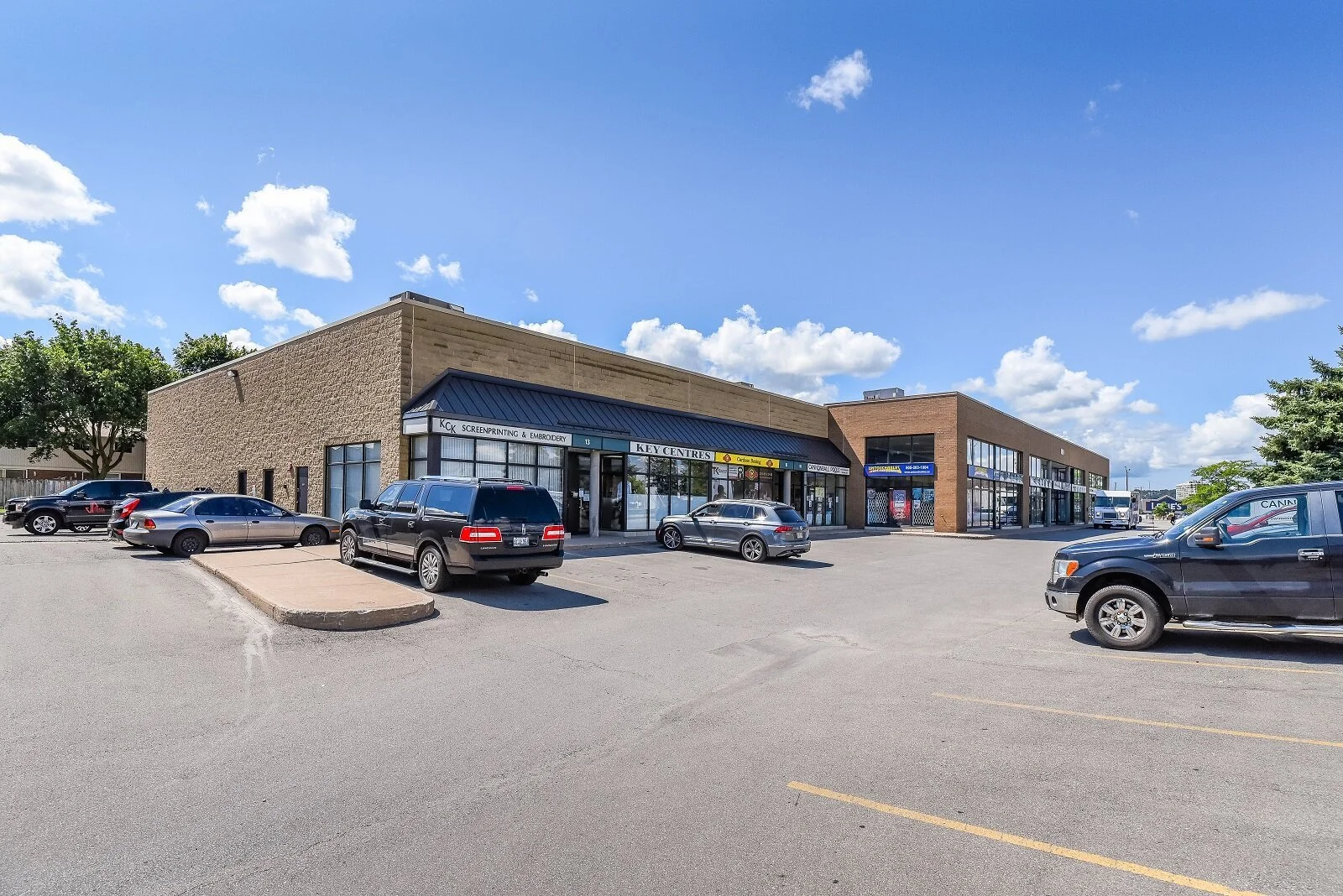 Storefronts and parking lot at 100 Nipissing Road in Nipissing Square, Milton