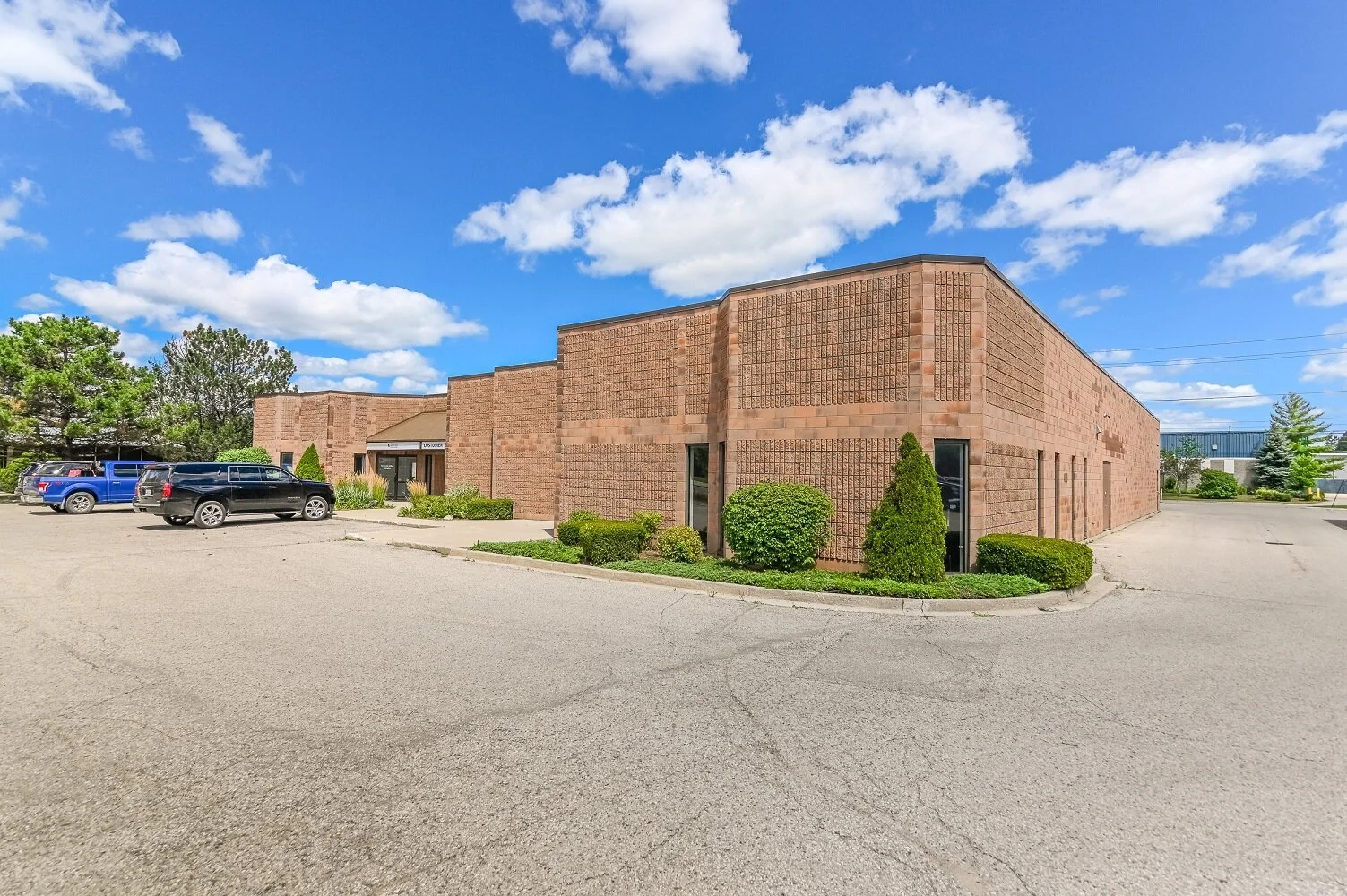 Brick building and parking lot at 337 Sovereign Road with landscaping